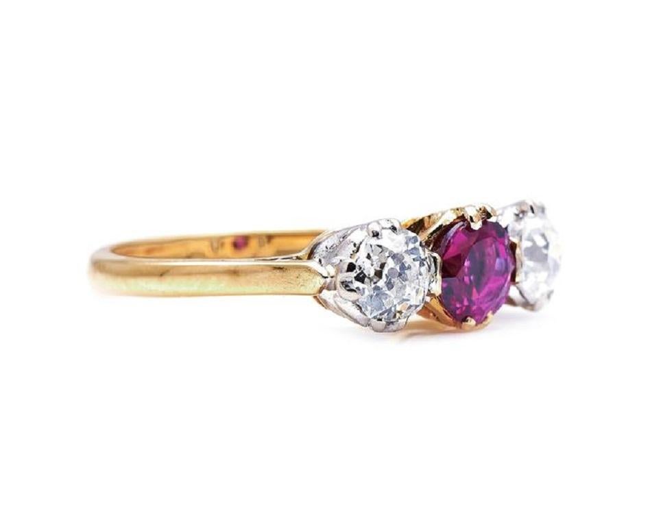 Ruby and Diamond Three-Stone Ring. ﻿Three-stone rings are a classic choice for an engagement ring, and this one is no exception. At the centre is a beautiful circular-cut ruby weighing approximately 0.60 carats, in a gorgeous shade of purplish red,