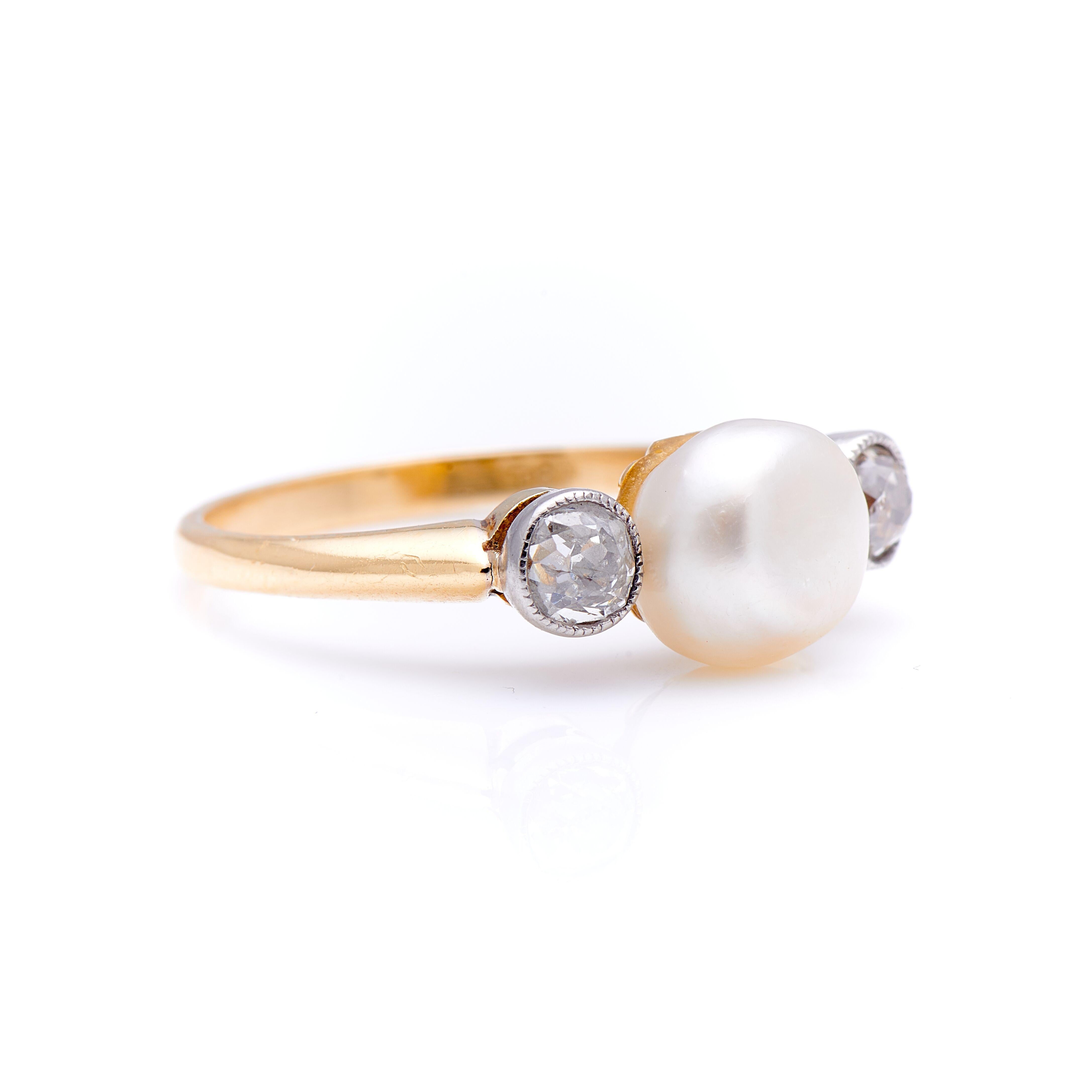 Edwardian, natural pearl and diamond three-stone ring, circa 1900. A delicately placed natural, saltwater, pearl sits centre with an perfectly irregular old-cut diamond set either side. The pearl is wonderful bouton shape with a shimmering white
