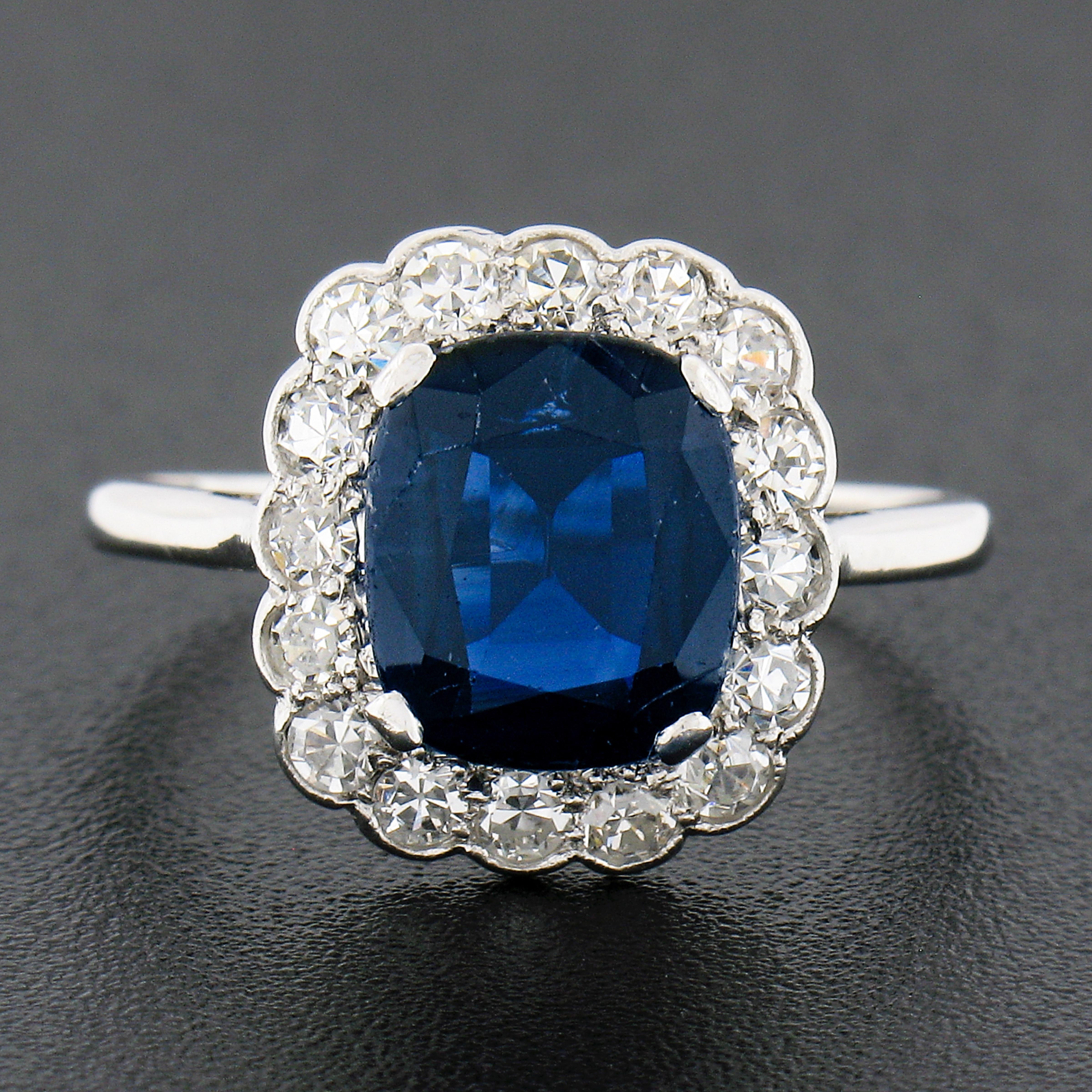 You are looking at a truly breathtaking antique sapphire and diamond ring that was crafted during the Edwardian period from solid 18k white gold and platinum. The ring features a gorgeous, cushion brilliant cut sapphire stone that is neatly prong