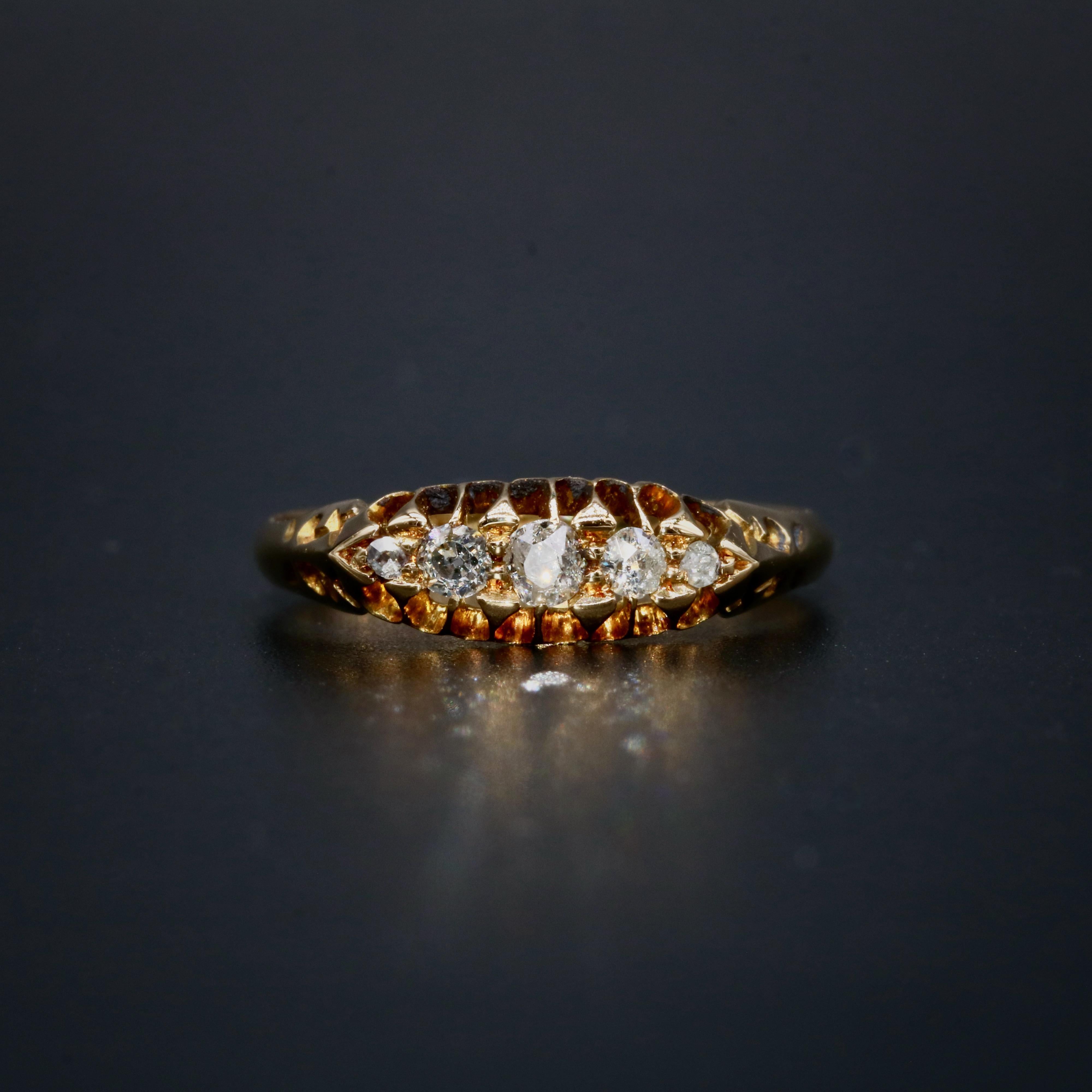 An antique diamond and yellow gold ring, comprising five old mine cut diamonds, set in 18 karat yellow gold, to a band of 18 karat yellow gold. 

The ring is set with 5 sparkling diamonds, which graduate from the centre out, creating a classic