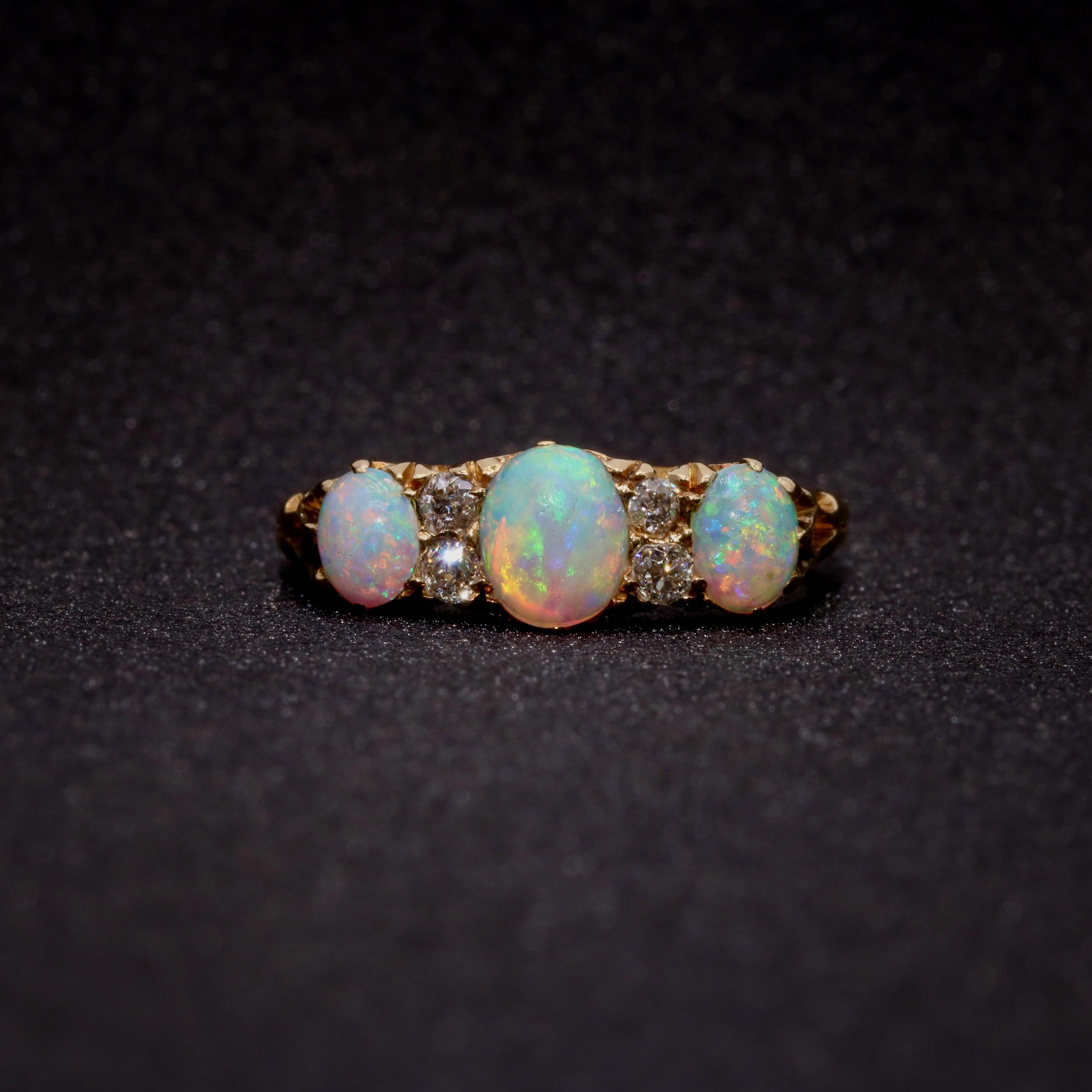 Bague ancienne en opale, diamant et or jaune, comprenant trois cabochons ovales en opale et quatre diamants de taille ancienne, en or jaune 18 carats. 

Ce que je préfère dans cette bague en or jaune antique avec opales et diamants, c'est l'éclat