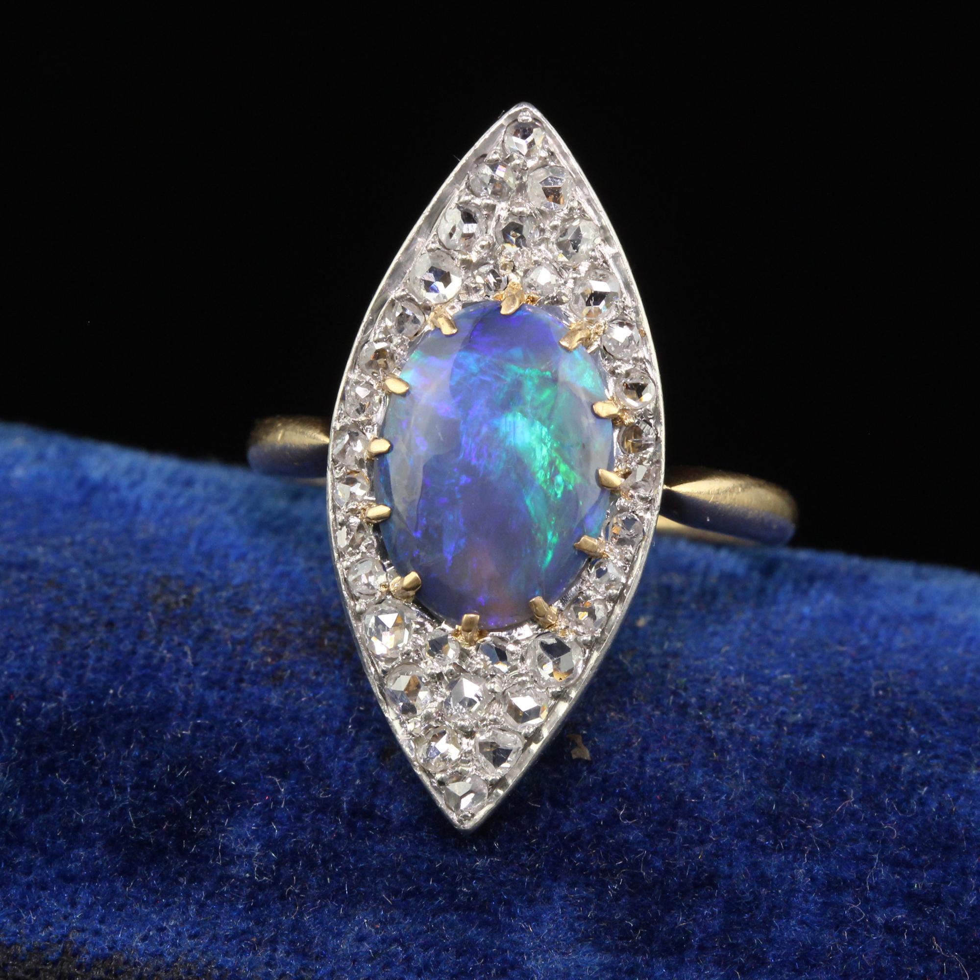 Beautiful Antique Edwardian 18K Yellow Gold Rose Cut Diamond and Black Opal Navette Ring. This gorgeous ring is crafted in 18k yellow gold and platinum top. The center of the ring holds a gorgeous cabochon black opal that has beautiful flashes of