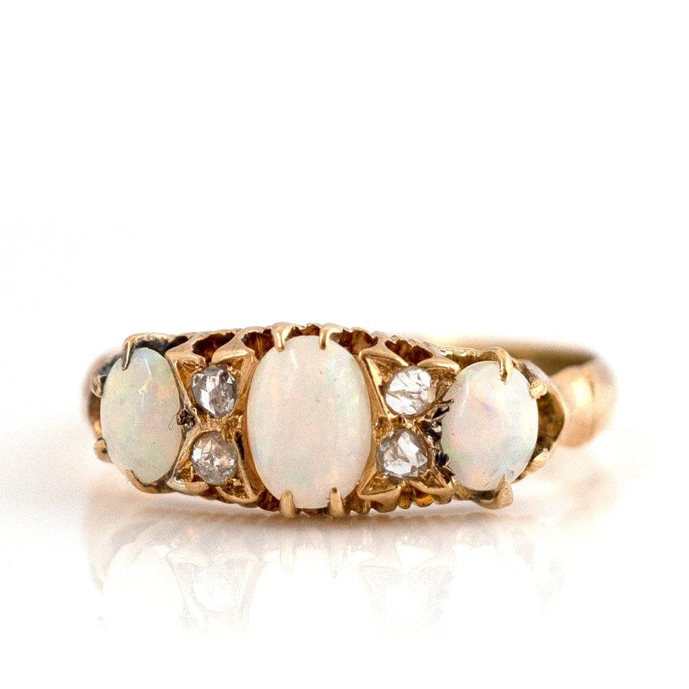 Our enchanting antique Edwardian 1903 Opal ring, showcases a trio of mesmerizing opals, nestled between sparkling diamonds, all set in a luxurious 18ct gold band. The breathtaking design is a true testament to the refined sensibilities of the