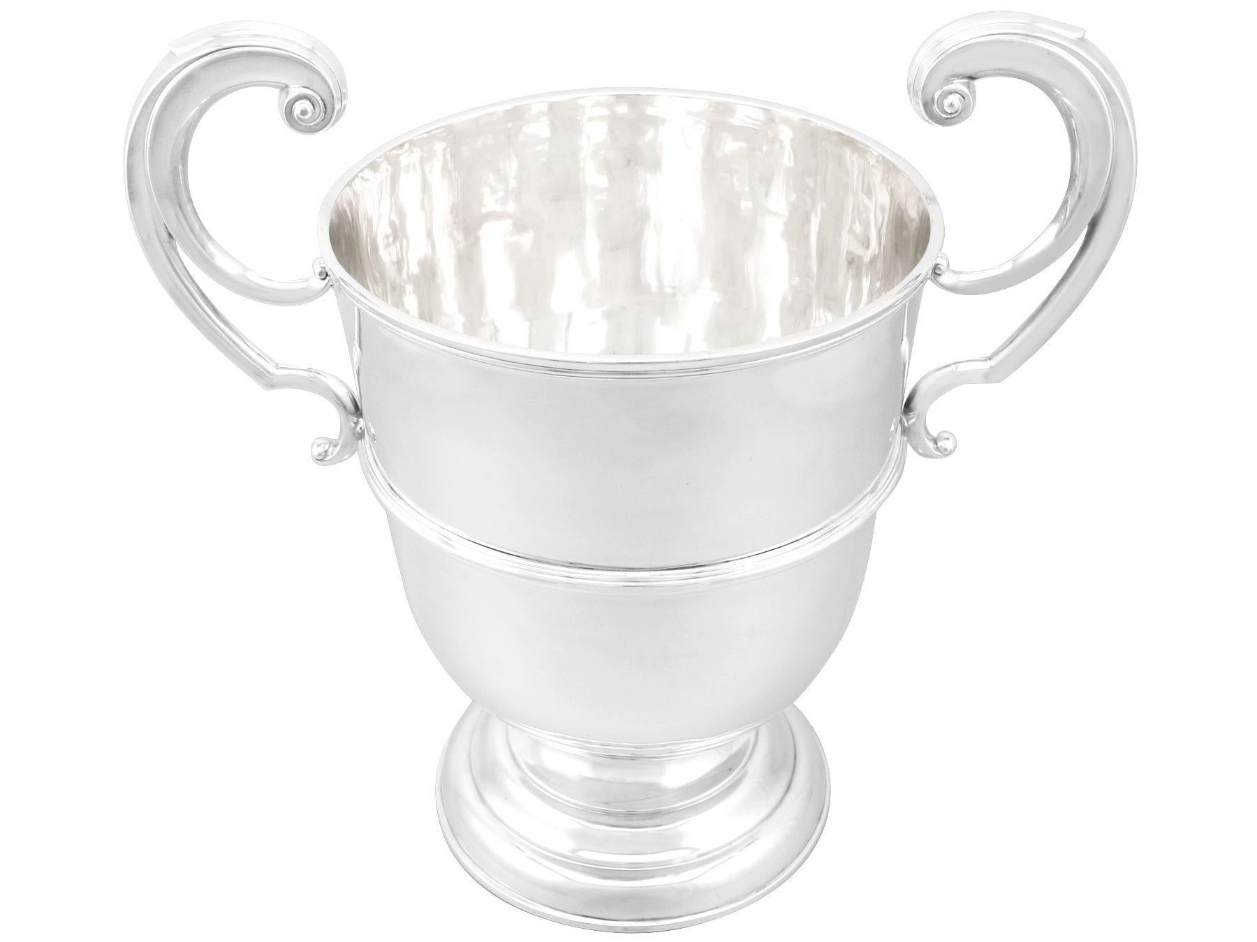 A magnificent, fine and impressive, large antique Edwardian English sterling silver champagne cup; an addition to our presentation silverware collection.

This magnificent antique Edwardian sterling silver cup has a plain bell shaped form to a