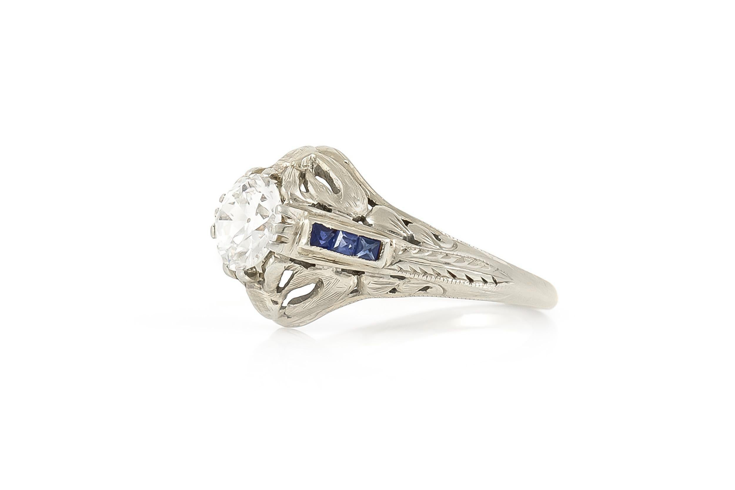 Finely crafted in 18K white gold with an Old European cut Diamond at the center weighing approximately 0.90 carat, G color, SI1 clarity, and accenting Square cut Sapphires. 
Circa 1910s
Size 6, resizable