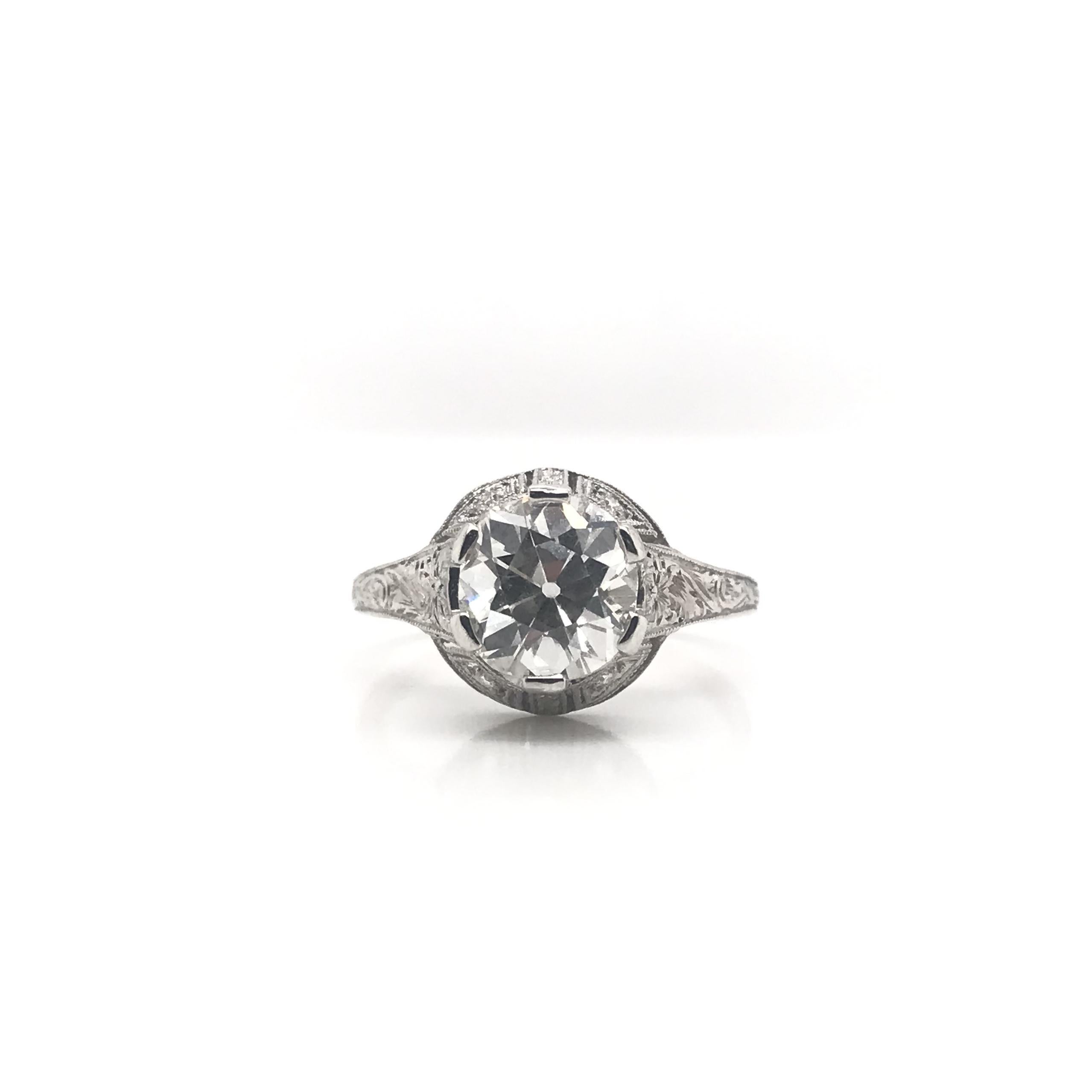 This antique piece was crafted sometime during the Edwardian design period (1900-1920). The platinum filigree setting features an antique center diamond measuring approximately 2.07 carats. The center diamond has been certified by the Gemological