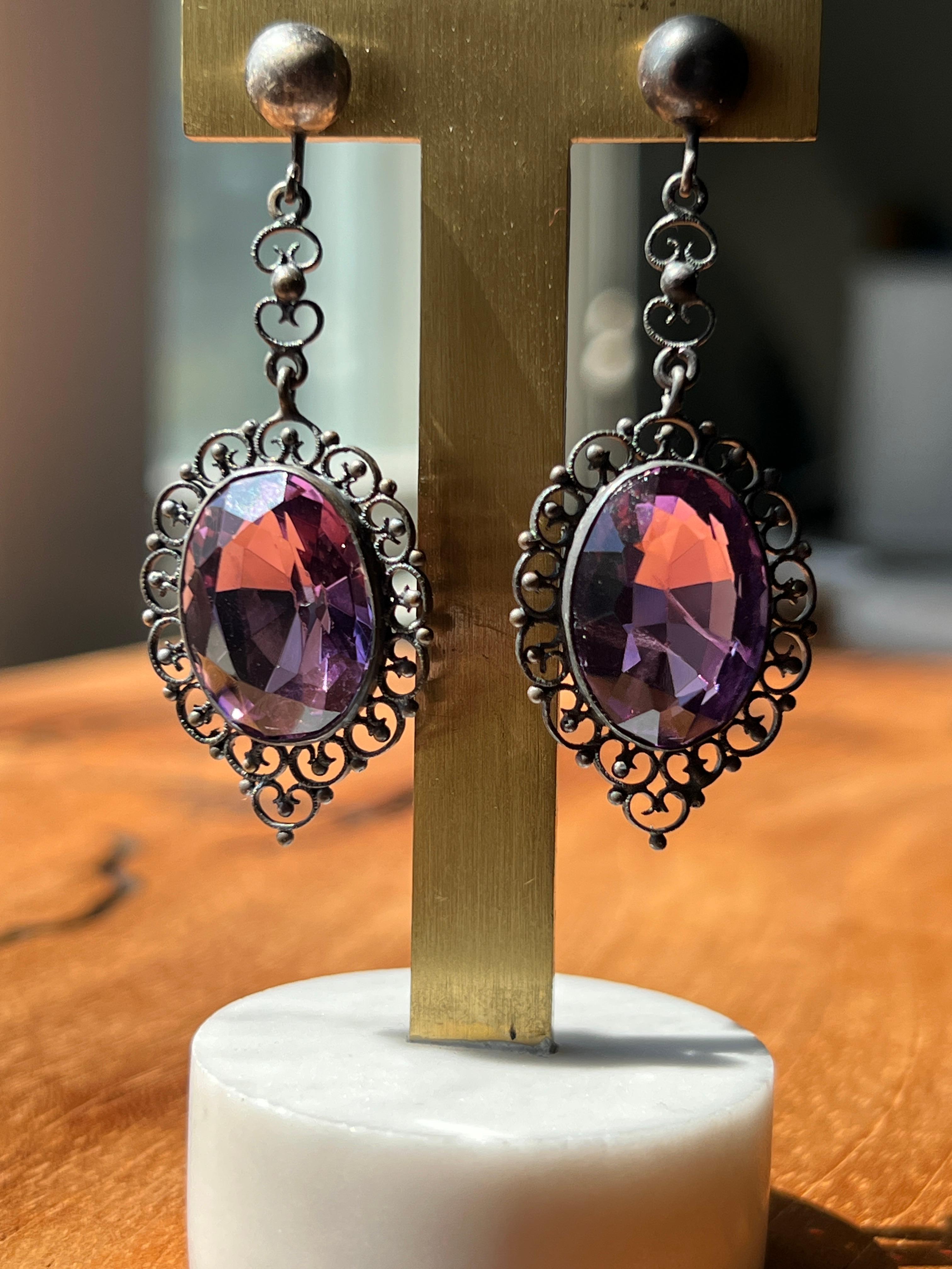 Un paio di antichi orecchini in argento sterling del 1915 circa, che completano perfettamente la raffinata eleganza del design edoardiano. Questi splendidi orecchini a goccia presentano due magnifiche ametiste dal taglio ovale per un totale di circa
