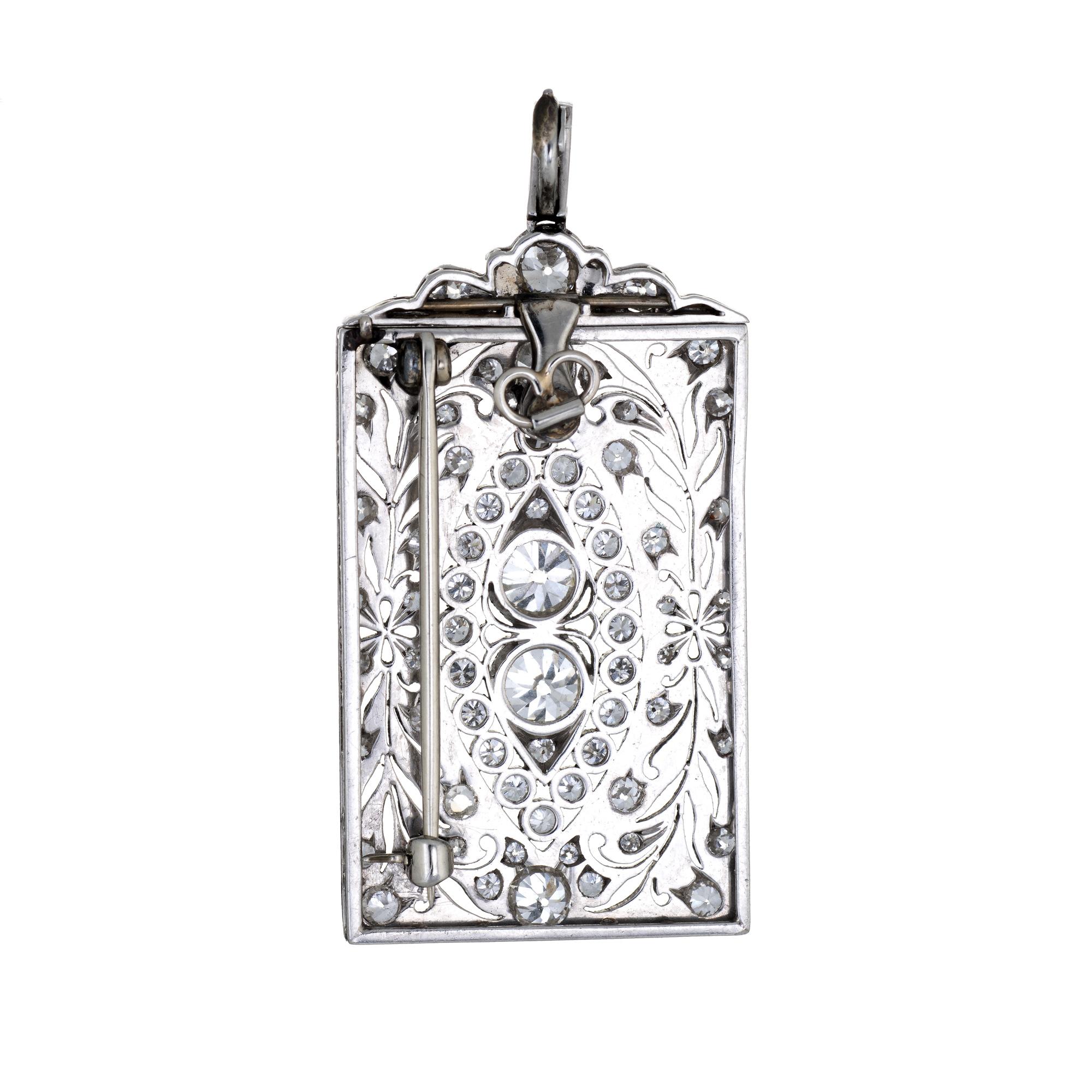 Finely detailed antique Edwardian pendant/brooch (circa 1900s to 1910s), crafted in 900 platinum. 

The pendant is set with old mine cut diamonds that total an estimated 3 carats. The larger center set diamonds are estimated at 0.75 carats each. The