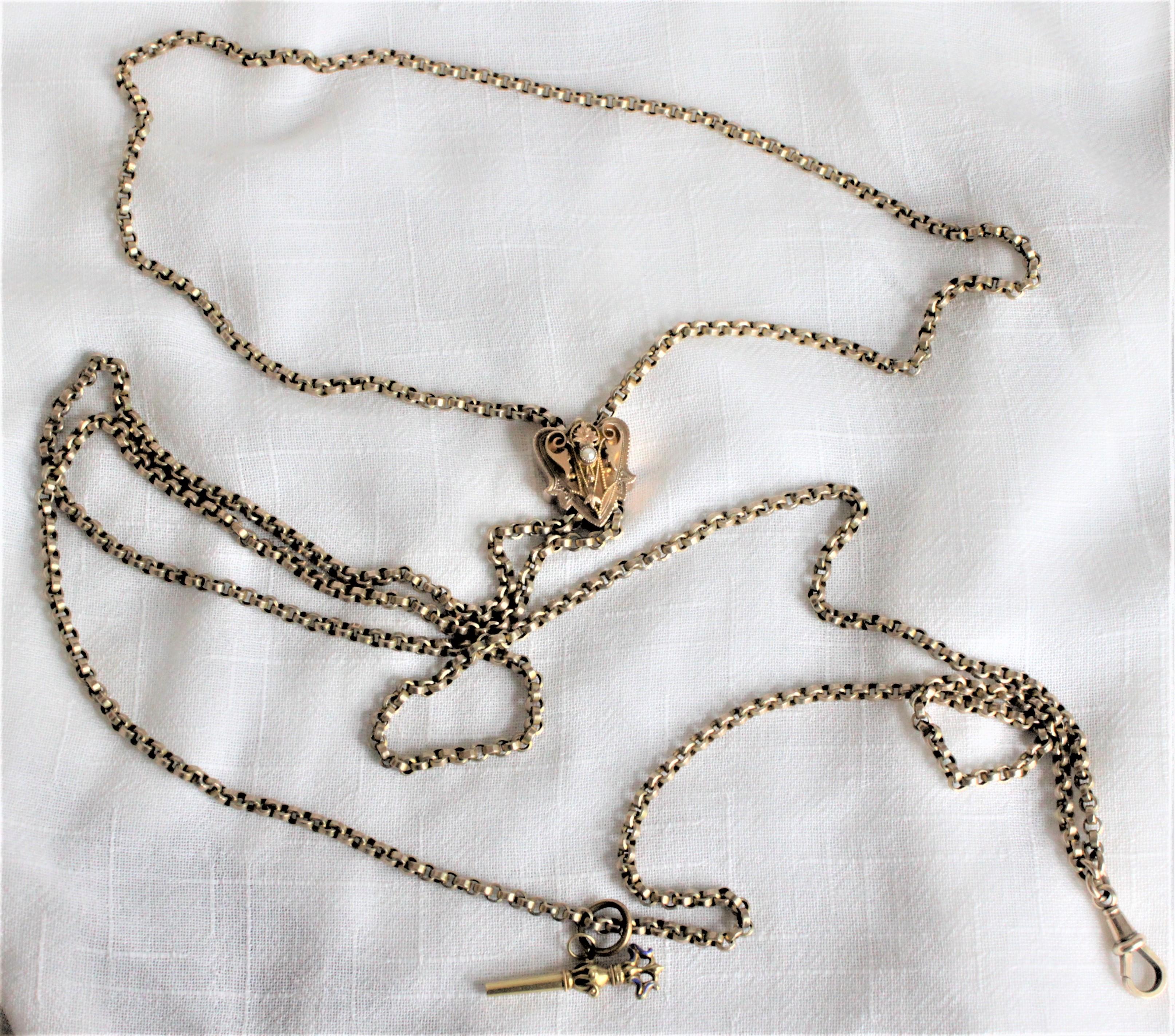 This antique 9-karat yellow gold watch chain is presumed to have originated from England and dates to circa 1880. This long and substantial tight round link chain features a shield shaped slide with ornate decoration and seed pear accents. The gold