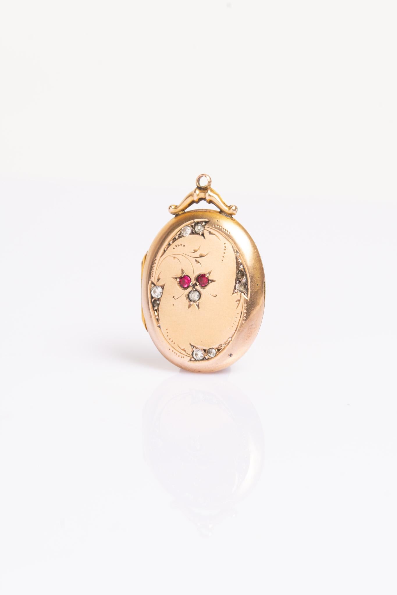 A charming Edwardian 9ct gold front and back paste floral locket. The front of the locket features seven white and two red paste stones. The locket opens to reveal two compartments for photographs. A lovely gift to someone you love or an excellent