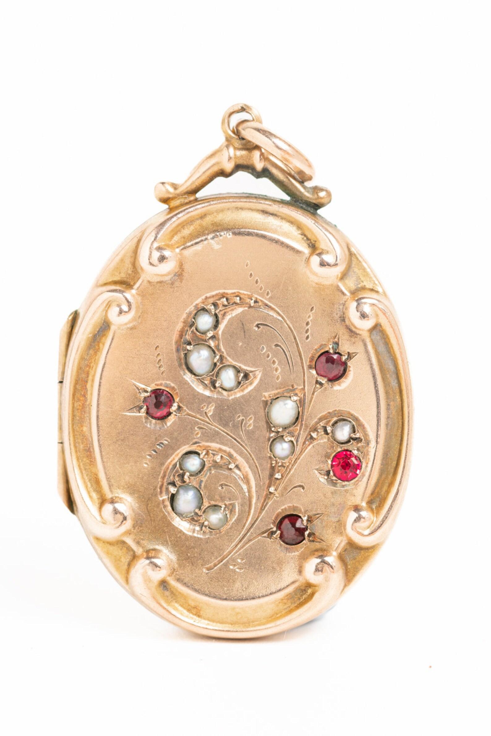 A charming Edwardian 9ct gold front and back seed pearl and ruby floral locket. The front of the locket features lustre seed pearls and rubies. The locket opens to reveal two compartments for photographs. A lovely gift to someone you love or an