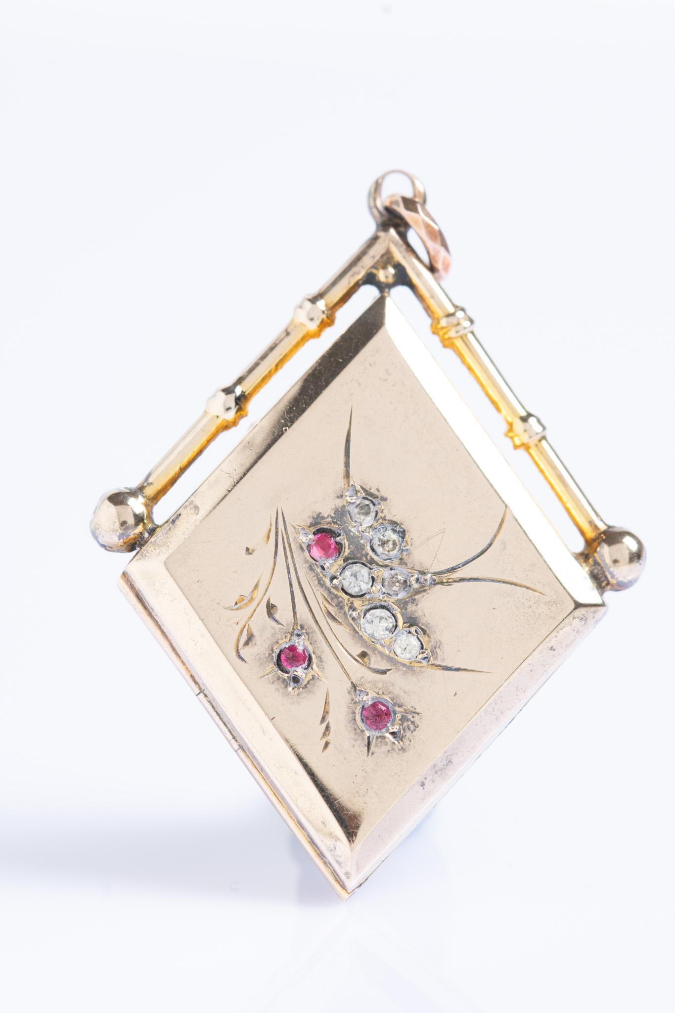 Ce magnifique et charmant médaillon en or 9ct de l'époque édouardienne en forme de losange a été fabriqué vers les années 1900. Le médaillon représente une hirondelle en vol entourée d'une guirlande de fleurs. Une hirondelle est rehaussée de pierres