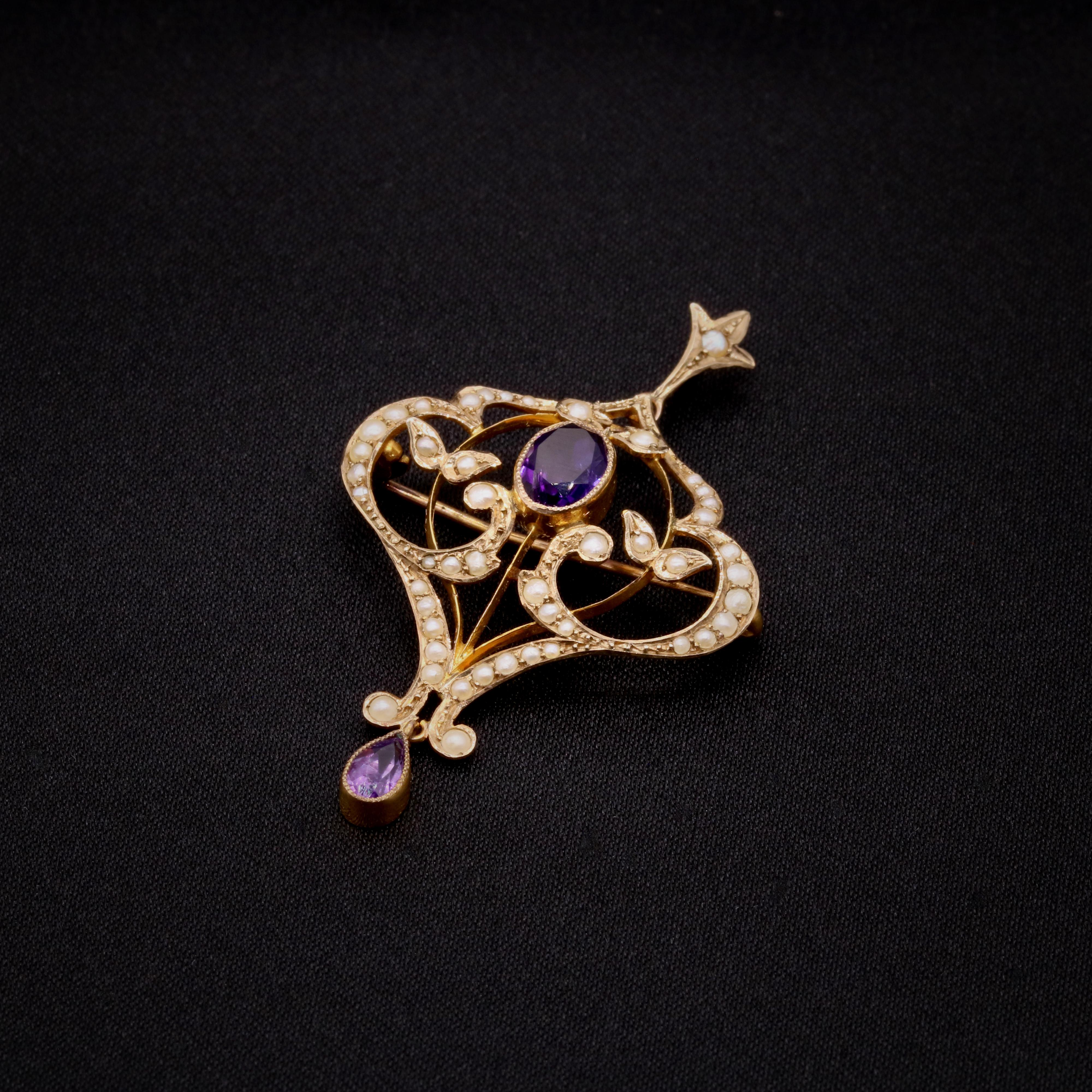Colgante o broche de finales de la época victoriana / principios de la eduardiana, de amatista, perlas y oro amarillo, compuesto por una amatista de forma ovalada y otra de forma de pera, y cuarenta y una medias perlas de pepita, en oro amarillo de