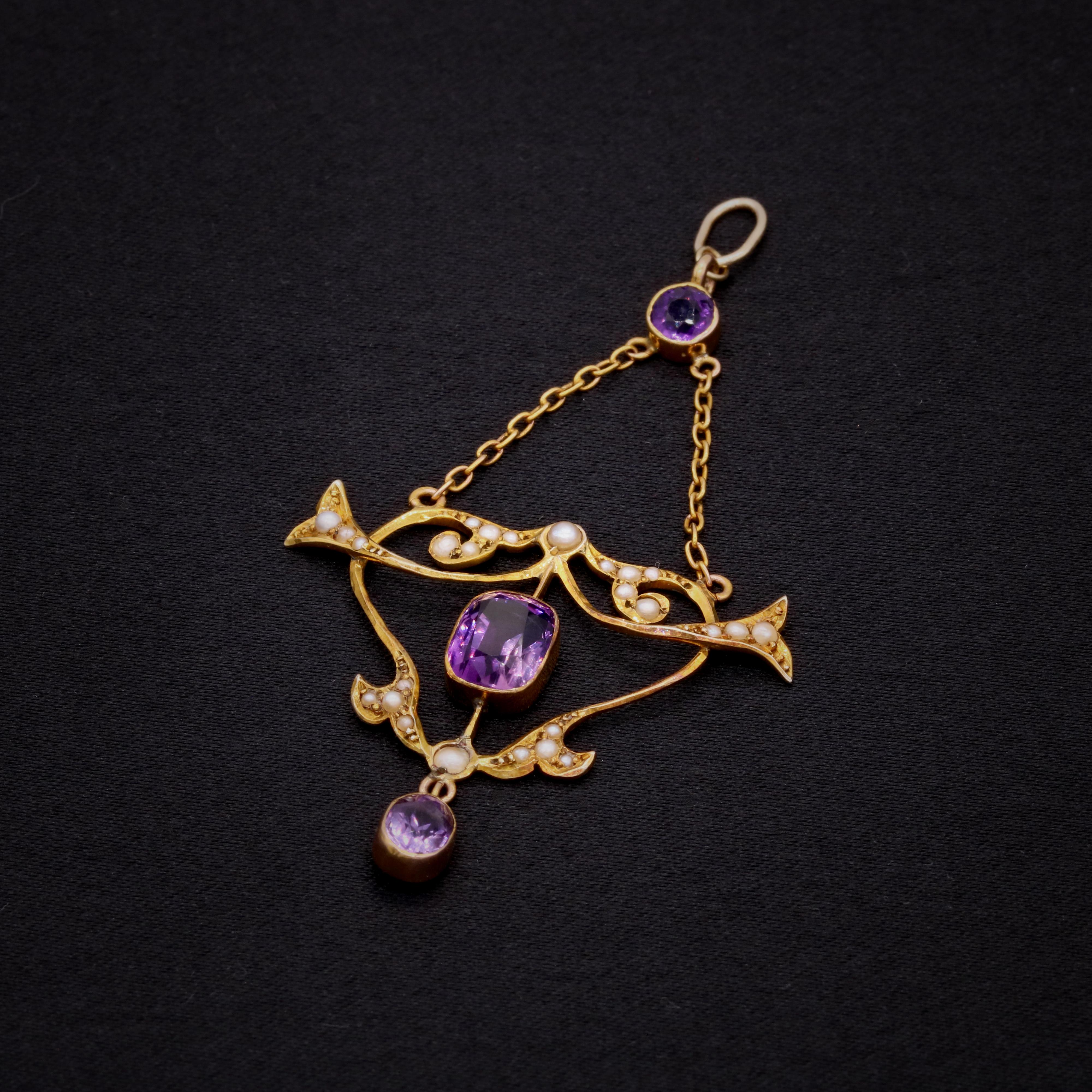 Pendentif ancien en améthyste, perle et or jaune, comprenant une améthyste de taille ronde, une améthyste de forme coussin, une améthyste de forme ovale et vingt-six demi-perles de rocaille, en or jaune 9 carats. 

Ce que je préfère dans ce