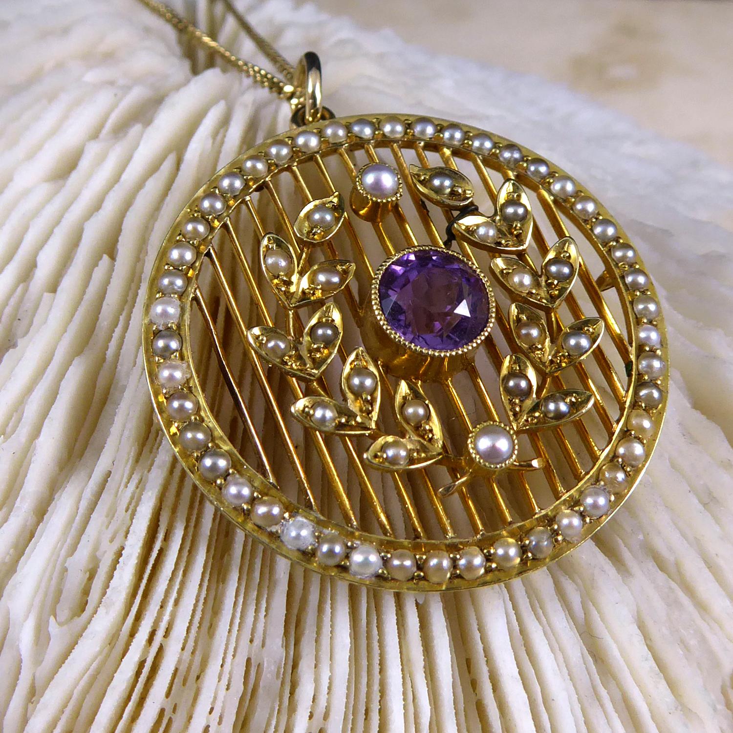 A beautiful Edwardian pendant set with a pleasing combination of amethyst with seed pearls.  The pendant is set to the centre with a round mixed cut amethyst of medium to dark colour in a milled grain edge collar mount.  The amethyst is encircled