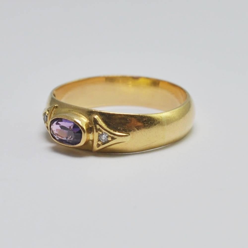Edwardian amethyst and diamond band ring;  this is set with an oval, horizontal, bezel set, amethyst with two small 8-cut diamond accents.  The ring weighs 3.3gms and would make a great antique wedding or stacking ring.  It has a wide band and is in