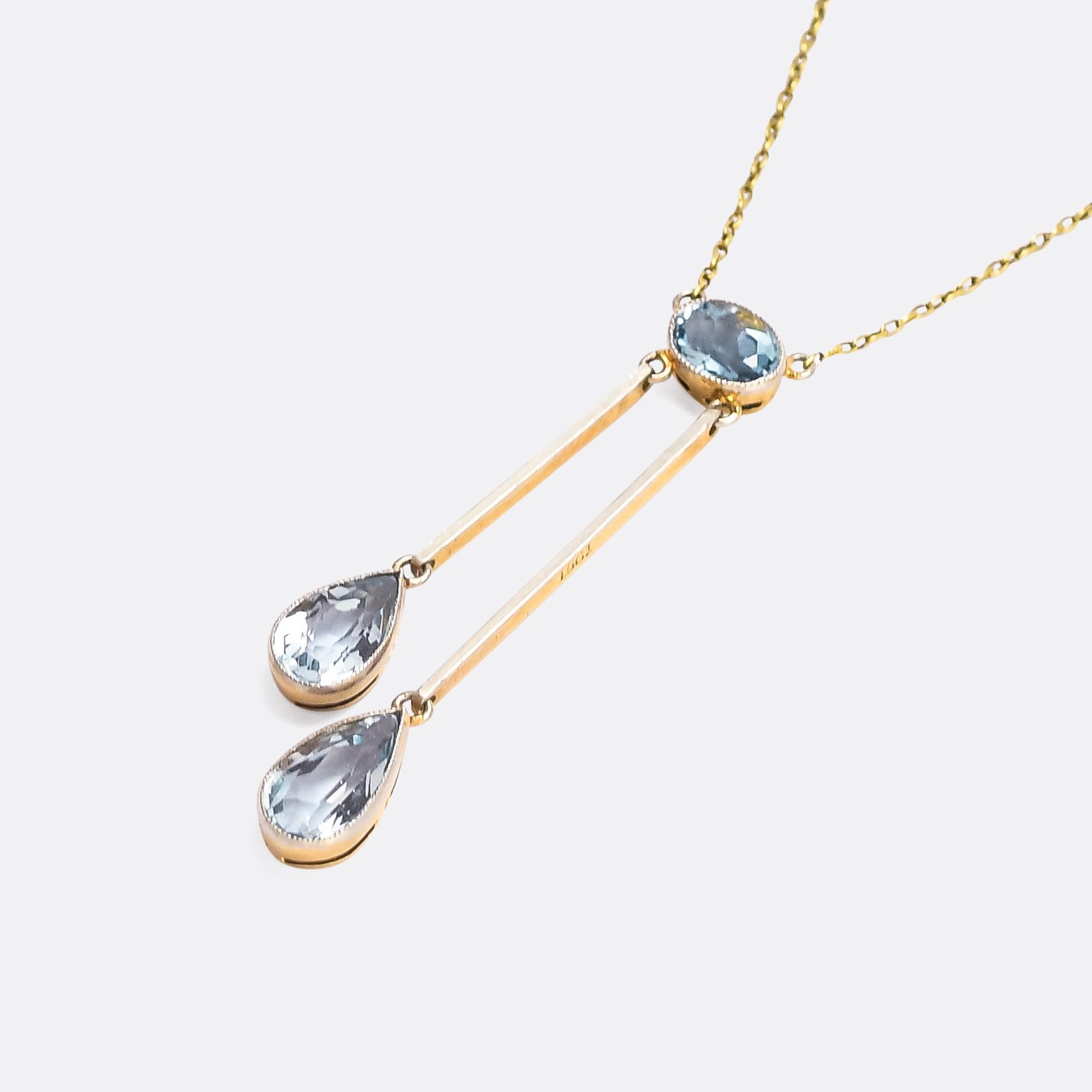 A stunning Edwardian negligee necklace set with three faceted aquamarines. The pendant consists of two pear cut drops of differing lengths dangling beneath an oval aquamarine top. It's crafted in 15k gold with millegrain platinum settings. A