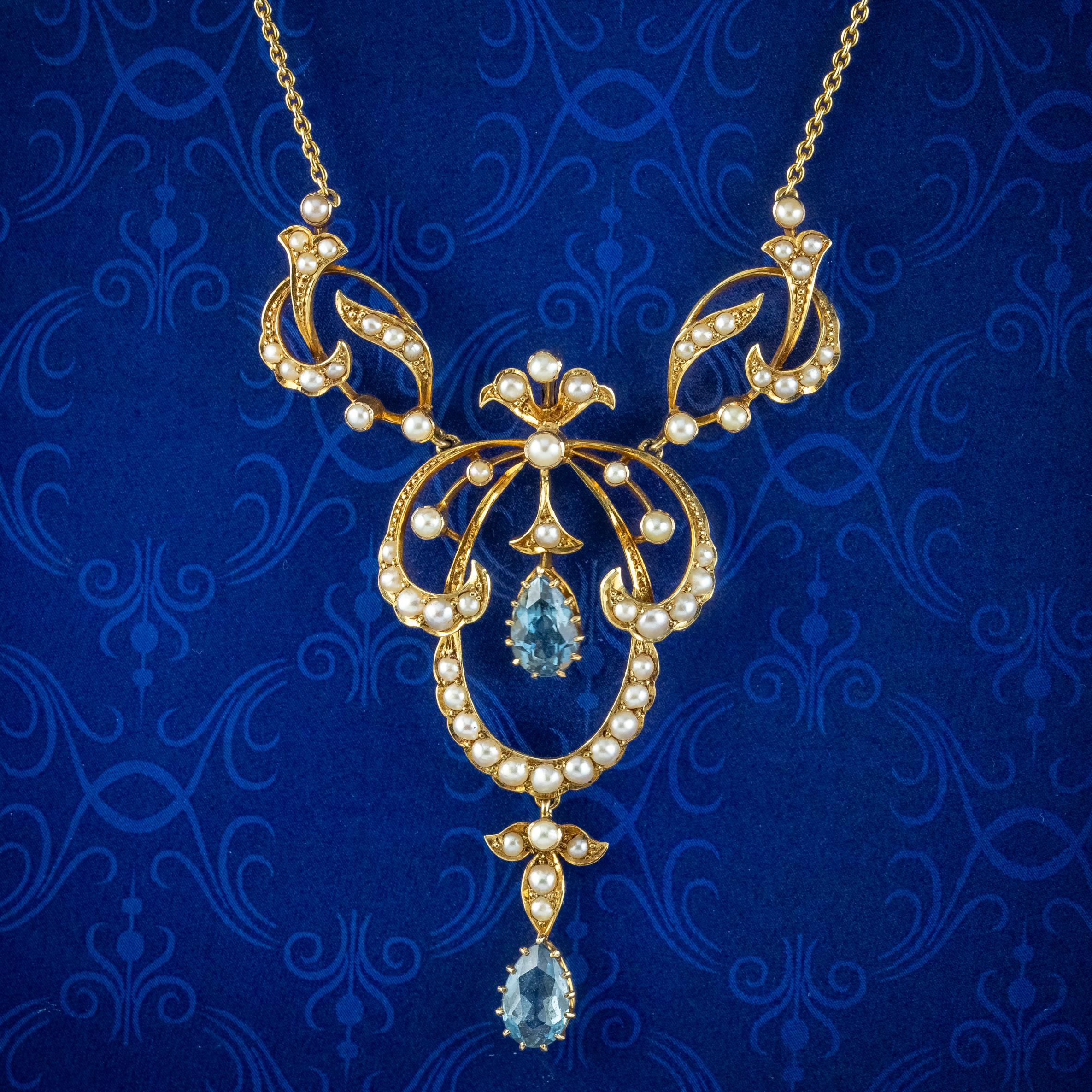 A fabulous antique Edwardian lavaliere necklace made in the Art Nouveau style. The pendant has a wonderful, open-work design with scrolling curves and foliate motifs decorated with gleaming white pearls and two pear cut aquamarine droppers (approx.