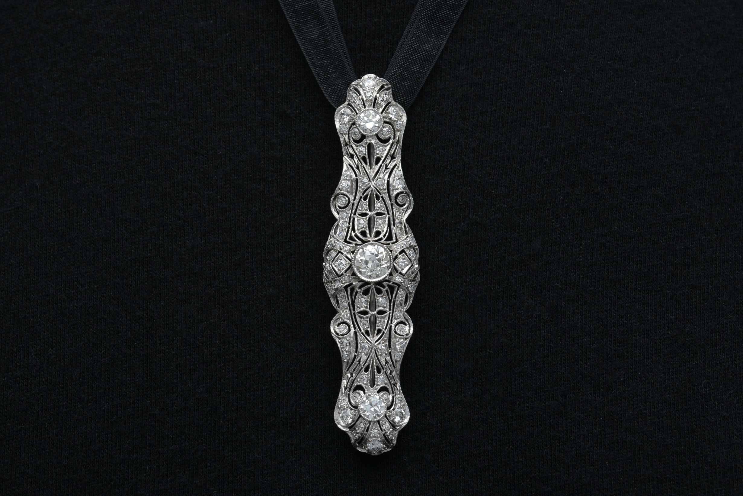 With the most mesmerizing pierced openwork filigree, this antique Edwardian Art Deco platinum brooch or pin is a most versatile accessory for your wardrobe. Admiring glances will notice the near 1 carat (0.96 ct.) fiery and brilliant old European
