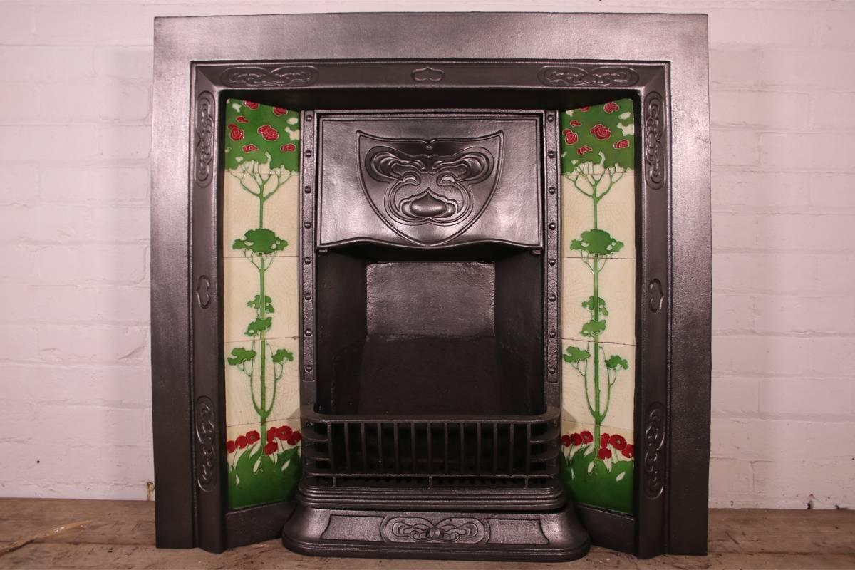 A good example of an antique Edwardian Art Nouveau cast iron and tiled grate with adjustable canopy. 
Complete with a set of original fireplace tiles (two tiles repaired). 

This grate has been finished the traditional black grate polish, leaving