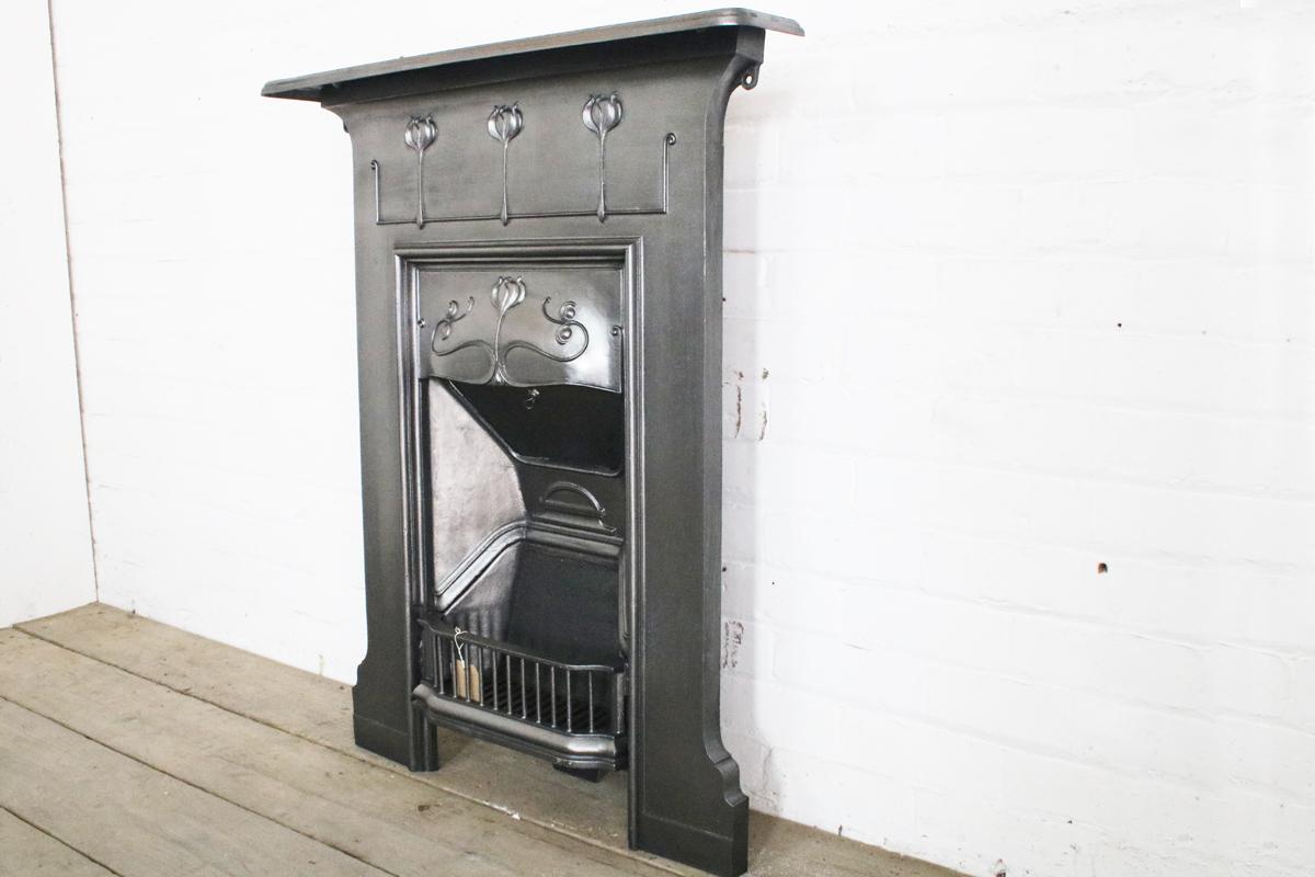 Antique Edwardian Art Nouveau cast iron combination fireplace with 3 erect tulips across the frieze and one to the canopy with sweeping tendrils. Dated 1905.

We currently have a suite of these fireplaces available. See final image. Priced