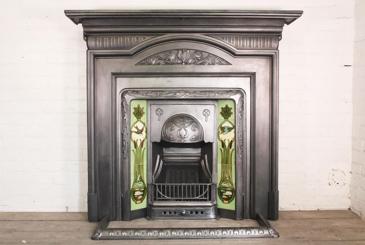 Antique Edwardian Art Nouveau cast iron fireplace surround with a stylized tulip to the frieze, circa 1905. Originally removed from an Edwardian property in Nottingham, England.

Pictured with an original cast iron and tiled grate and antique