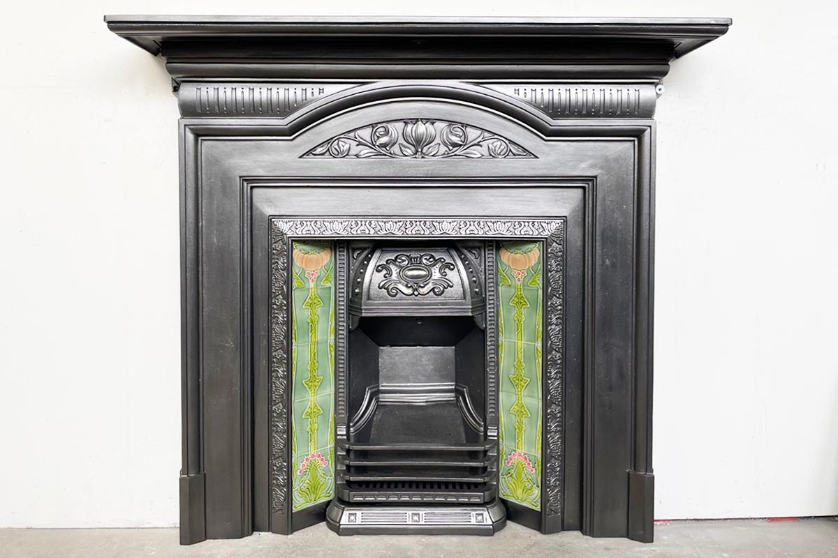 Restored antique Edwardian Art Nouveau cast iron fireplace surround with a styalised tulip to the frieze. Circa 1905.

For detailed sizes please see the size diagram in the image gallery.

The surround has been finished with traditional black grate