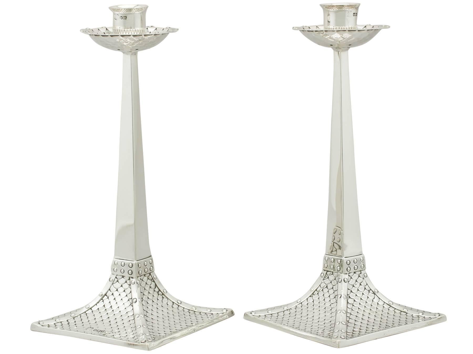 An exceptional, fine and impressive pair of antique Edwardian English sterling silver candlesticks in the Arts & Crafts style; an addition to our ornamental silverware collection.

These exceptional antique Edwardian silver candlesticks, in