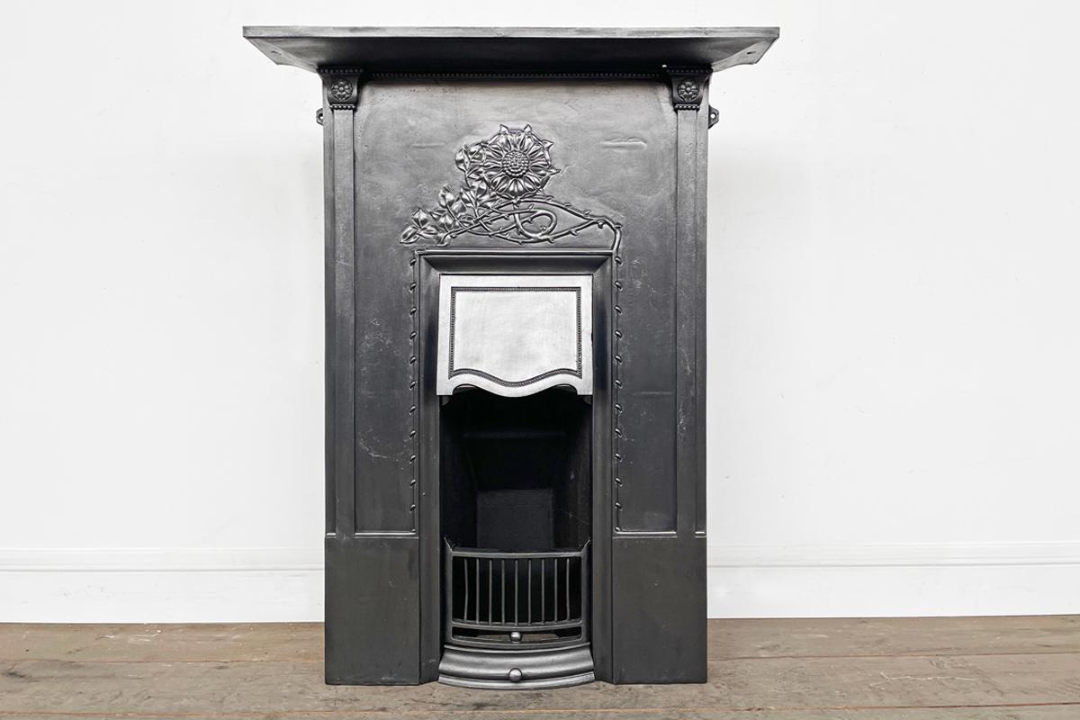 Tall original antique Edwardian cast iron combination grate with a central rose the the deep frieze with its flowing stem and leaves twisting below, all above a simple but adjustble canopy and fire grate.

This fireplace has been finished with