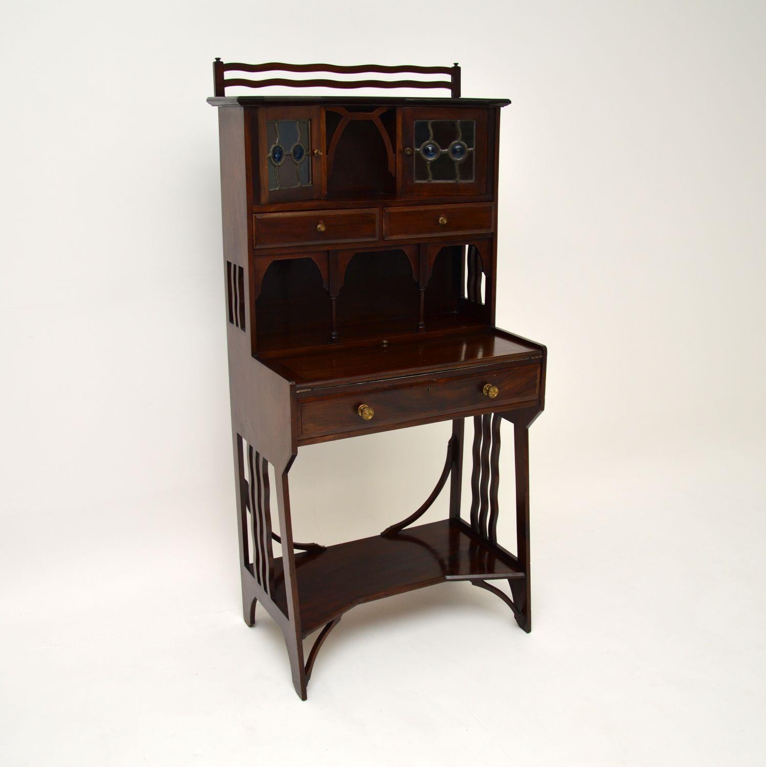 A lovely antique Arts & Crafts period bureau in solid mahogany, dating from around the 1890-1900 period.
This is of excellent quality and has a beautiful design. The writing surface flips out and rests on the open drawer. There is additional