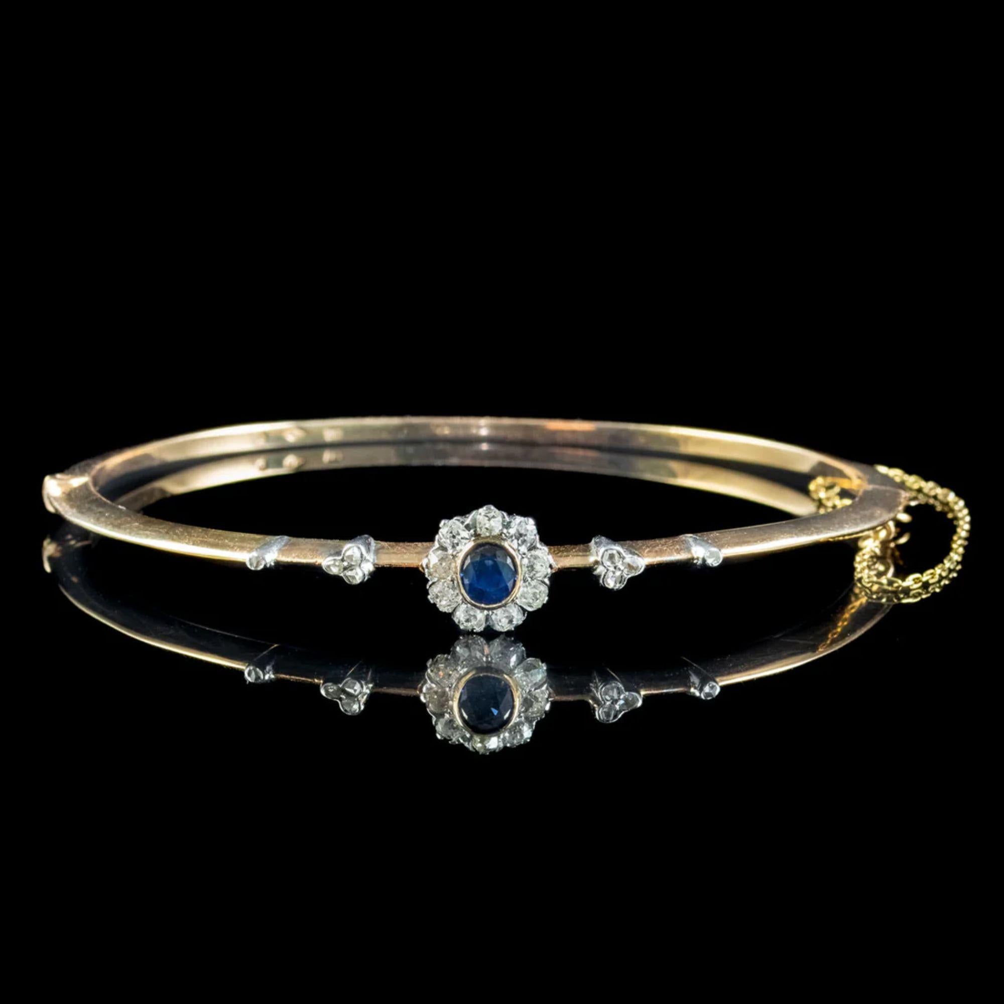 An elegant antique Austro-Hungarian bangle from the early 1900s crowned with a deep blue sapphire bezel set in the centre of a platinum flower (approx. 0.55ct). It’s complemented by a halo of nine bright cushion cut diamond petals with further