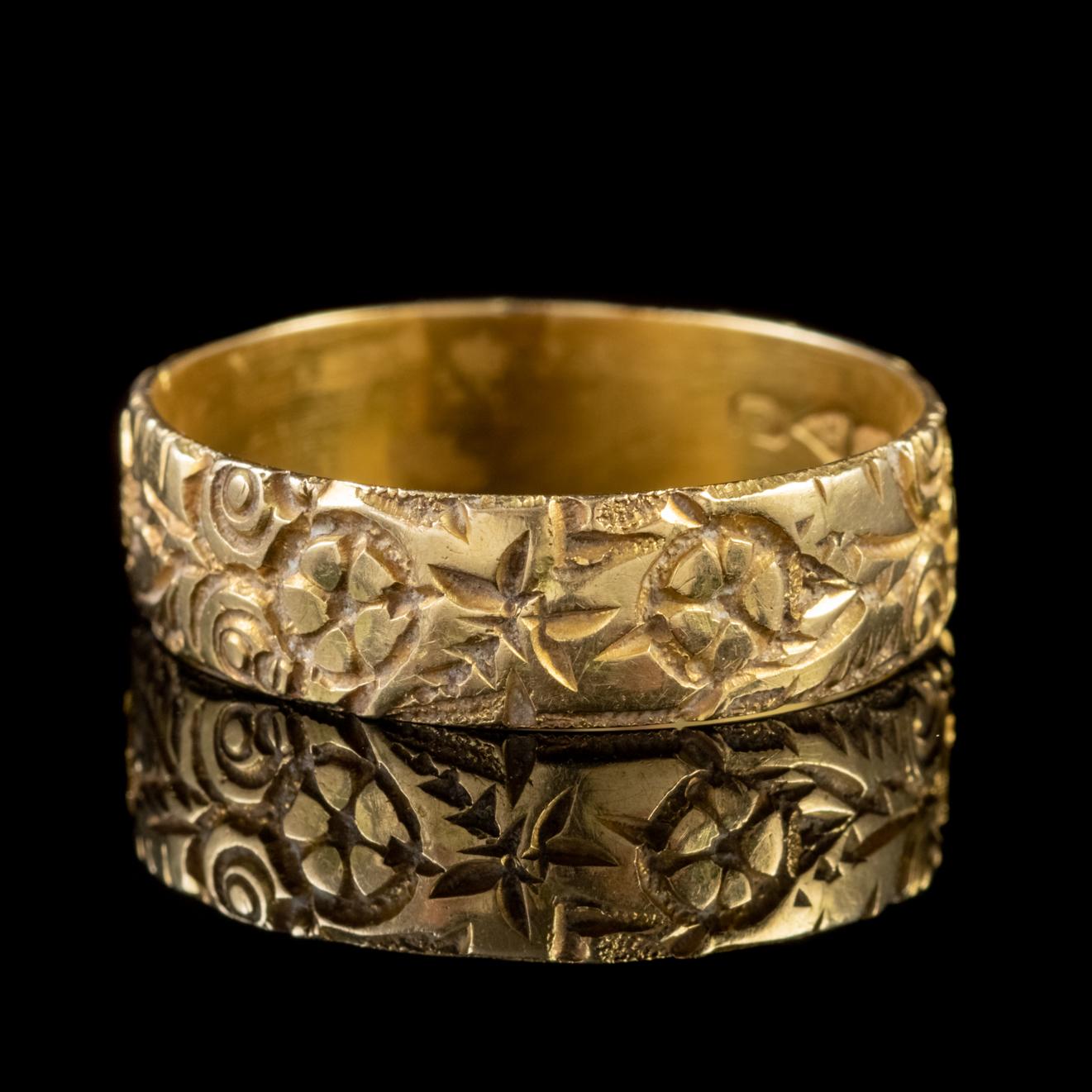 A grand Antique Edwardian band ring modelled in solid 18ct Yellow Gold and engraved with detailed Forget me nots which encircle the band in a lovely decorative fashion. 

Forget me nots in an old German tale were discovered by two lovers walking by