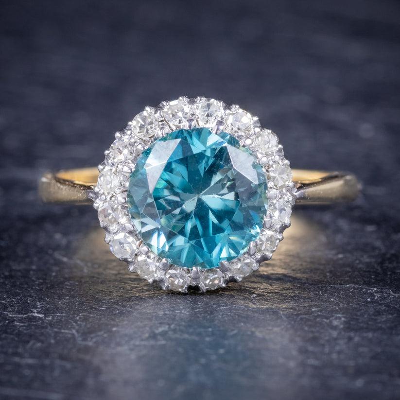 A fabulous antique Edwardian cluster ring (C. 1910), adorned with a beautiful 3.21ct (approx.) blue Zircon surrounded by a halo of Diamonds with beautiful SI1 clarity - H colour (approx. 0.80ct total).

The stones are set in a Platinum gallery and