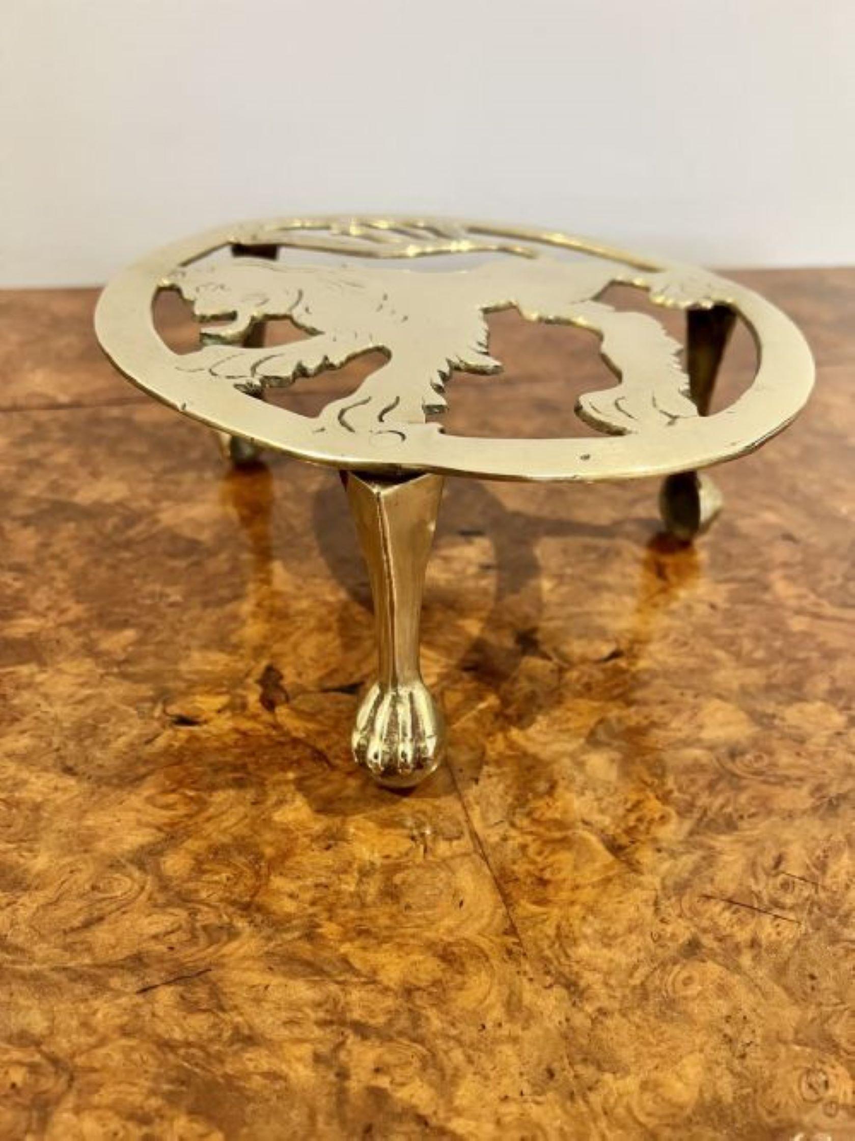 Antique Edwardian brass circular trivet having a circular trivet, with a lion to the top standing on three brass paw feet