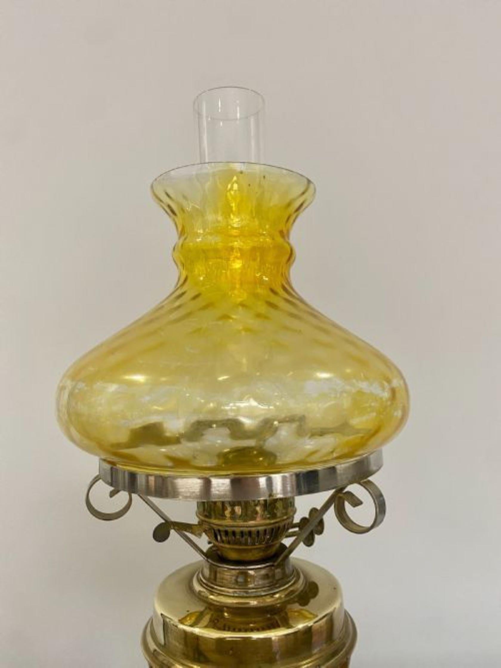 Antique Edwardian brass oil lamp having the original glass shade, double brass burner, brass front supported by a brass column raised on a brass circular stepped base