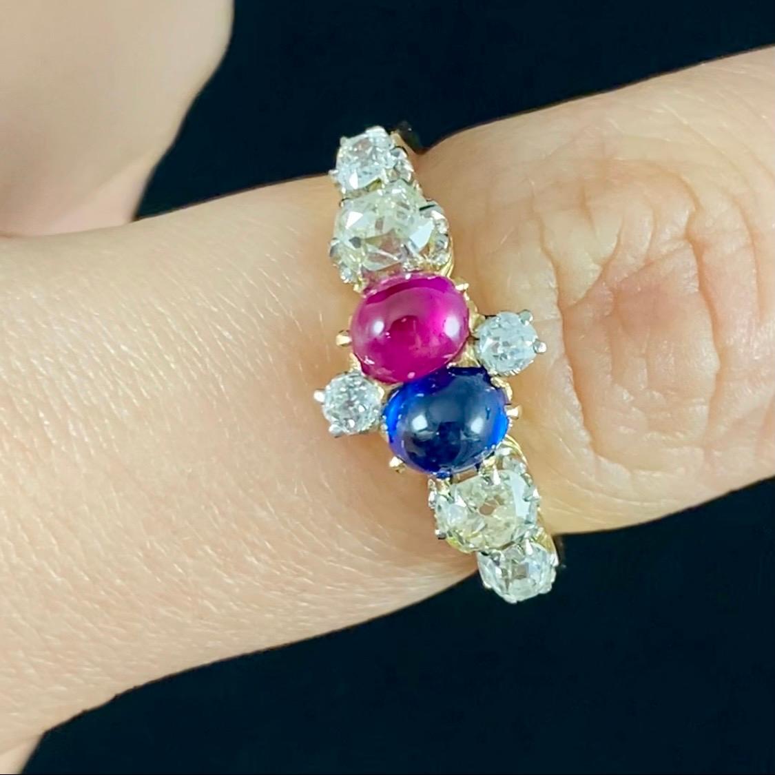 Antique Edwardian Sapphire, Ruby and Old Cut Diamond Ring in Gold, c. 1915. This jewel consists of a central cruciform motif composed by two Old European brilliant-cut diamonds and two cabochon gemstones of probably Burmese origin - a royal blue