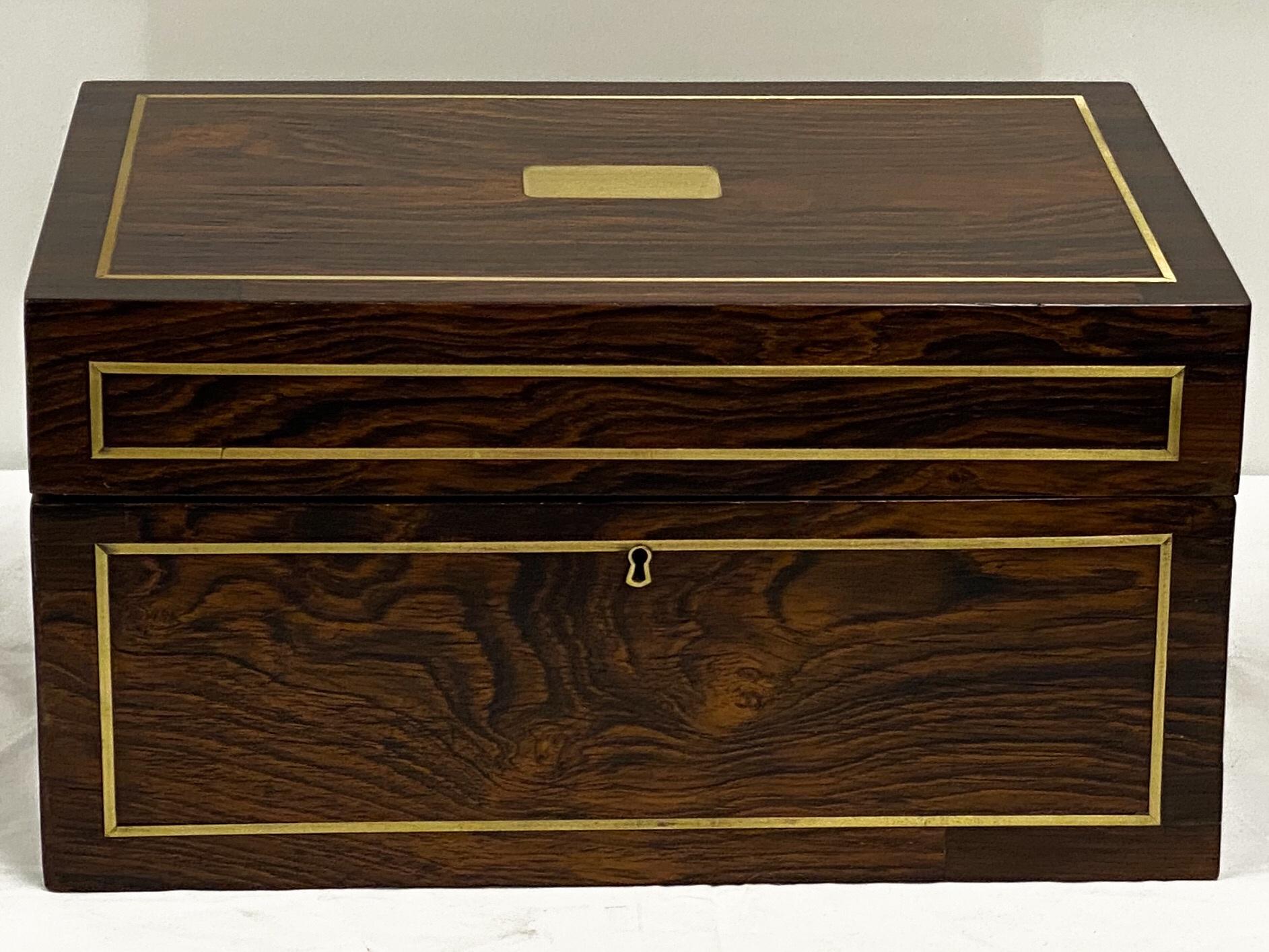 This is an antique English rosewood humidor with campaign styling by Benson & Hedges. It has brass inlay and other appointments that are in very good condition. It is marked on the interior and is of the Edwardian period.