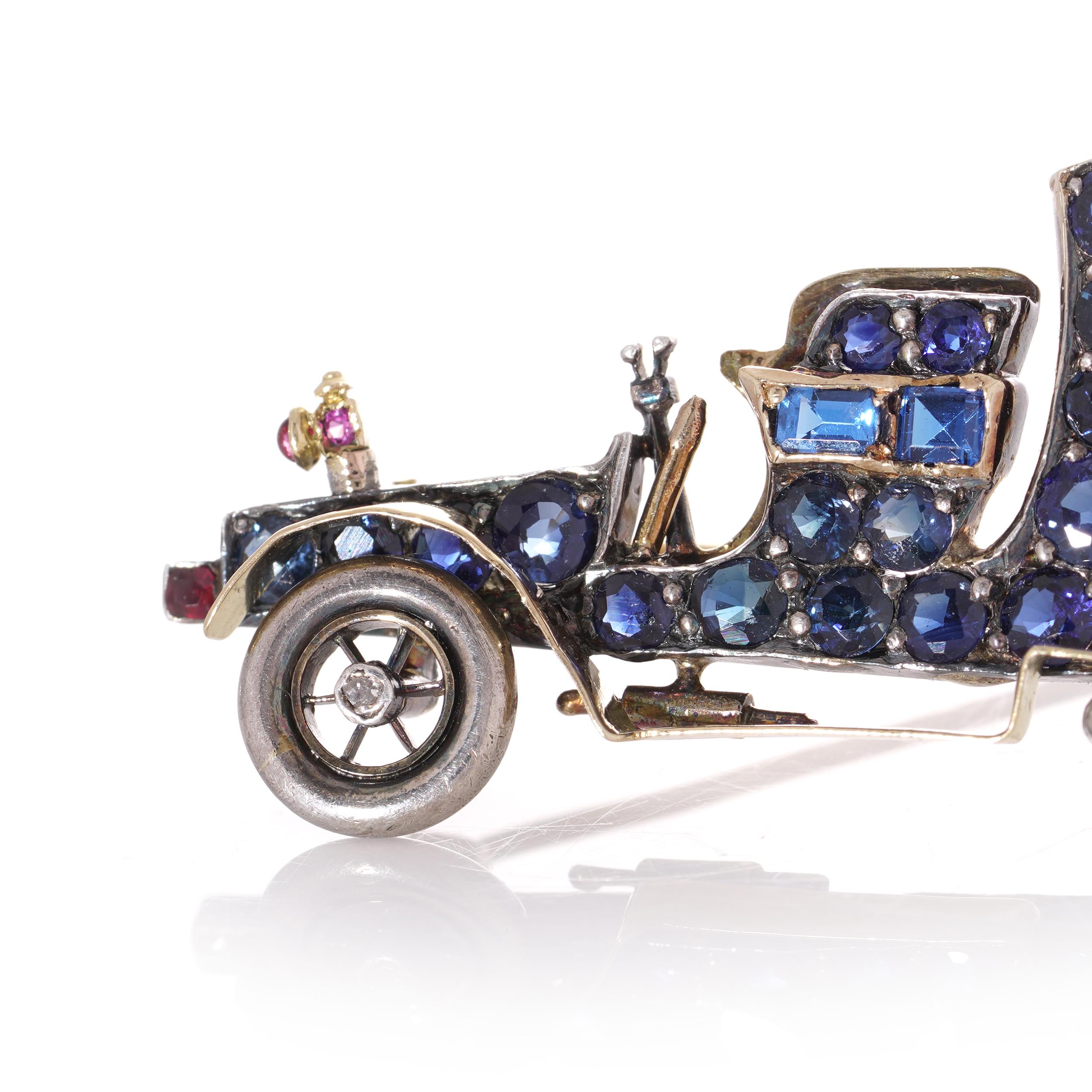 Antique Edwardian 15kt. yellow gold and silver car automobile brooch, set with blue sapphires. rubies and emerald.

Dimensions -
Weight: 11.8 grams
Size: Length x width x depth: 4.2 x 3.3 x 0.7 cm
Height: 4.2 cm

Sapphires -
Cut: Round faceted,