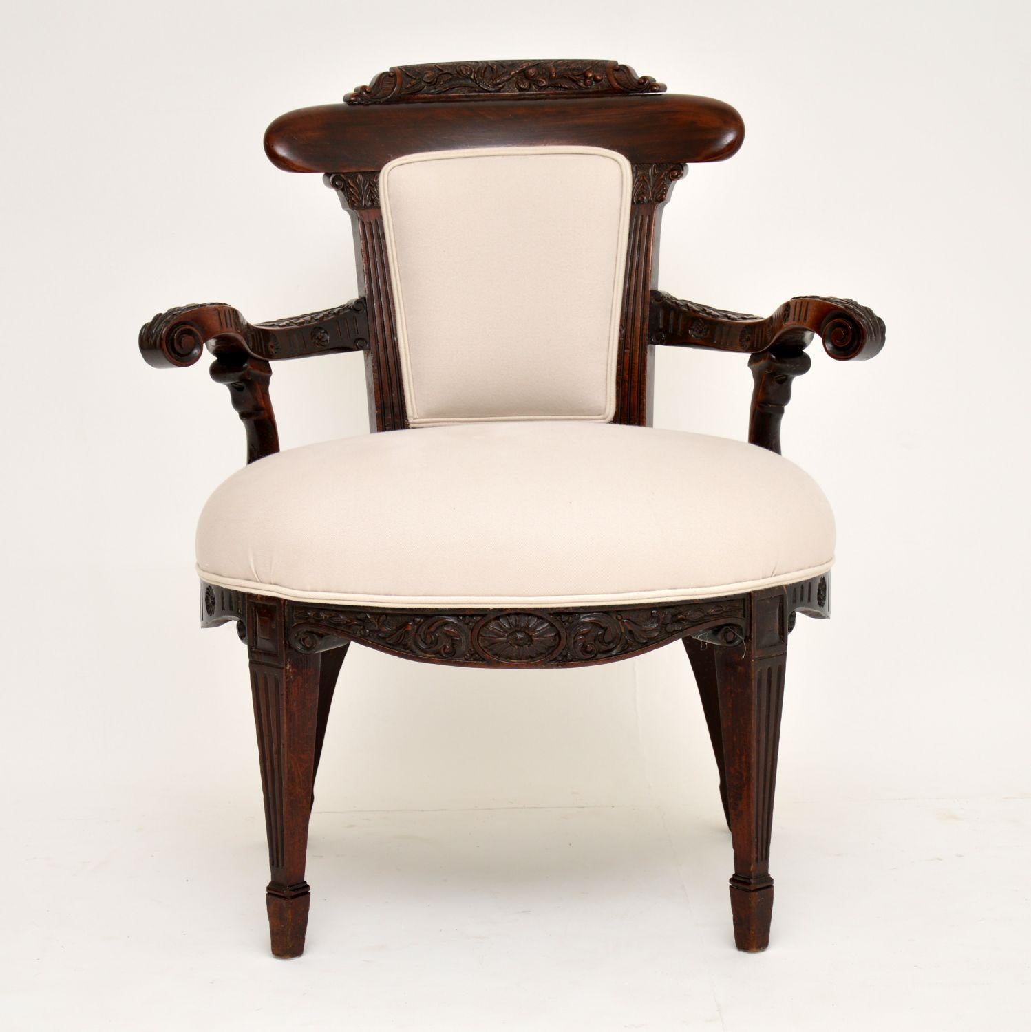 This antique Edwardian mahogany armchair dating from the 1890-1910 period is very high quality and has wonderful shaping all over. It has very generous proportions and is carved all over. There is a carved floral panel on the top with capitals below
