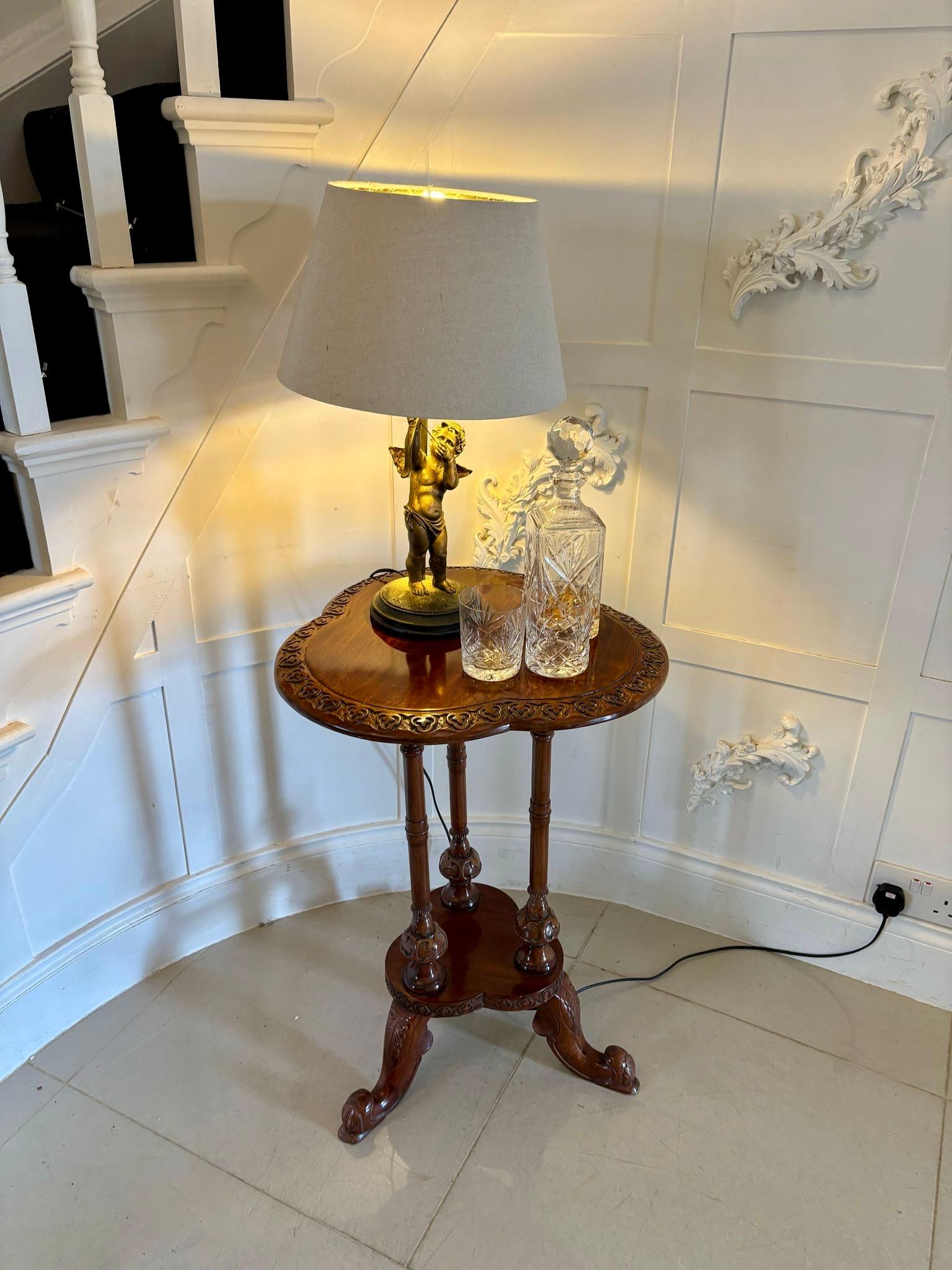 Ancienne table de lampe en acajou sculpté de l'époque édouardienne, avec un beau plateau en acajou sculpté, soutenu par trois colonnes tournées et sculptées, sur une plate-forme reposant sur des pieds cabriole sculptés et façonnés.

Une table