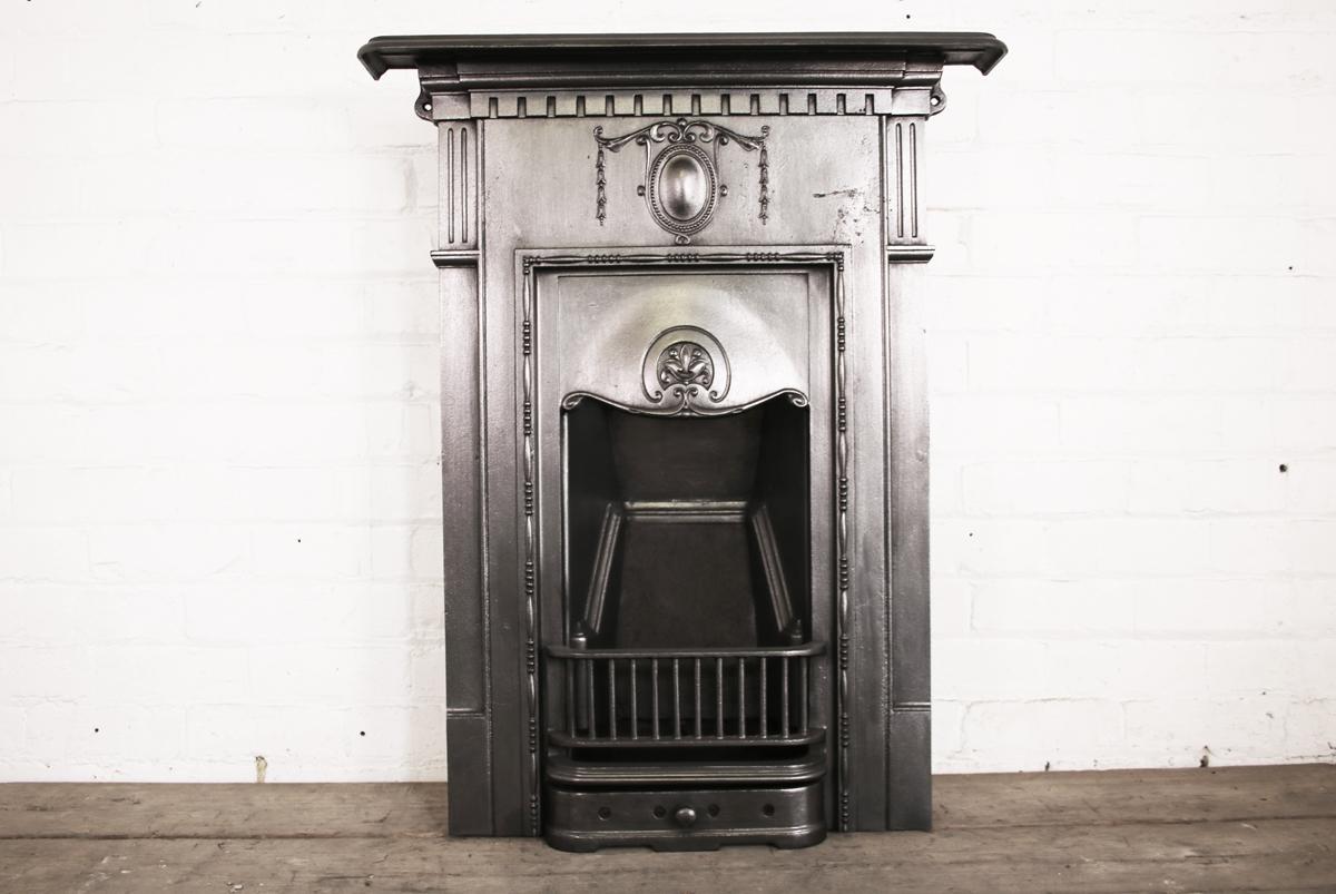 Antique Edwardian cast iron bedroom fireplace in the classical manner, circa 1900. 

This fireplace has been finished the traditional black grate polish, leaving a gun metal / pewter shine.

Ready to be installed and used for a real coal or log
