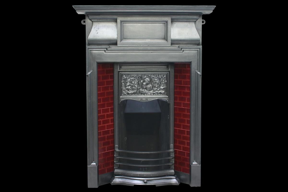 Antique Edwardian cast iron combination grate of simple form with a decorative canopy in the Rennie Mackintosh style. Complete with original deep red briquette tiles.

This grate has been finished the traditional black grate polish, leaving a gun