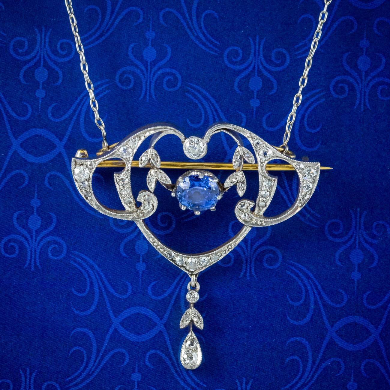 An elegant antique Edwardian lavaliere necklace adorned with a beautiful Art Nouveau pendant decorated with twinkling old cut diamonds (approx. 0.80ct total) and a vibrant blue cushion cut Ceylon sapphire at its heart weighing approx. 1ct. It’s