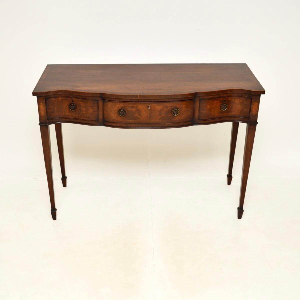A wonderful antique Edwardian console table, made in England and dating from the 1900-1910 period.

This is of superb quality and is a great size, with beautiful design features. It has a serpentine shaped front and stands on tapered legs