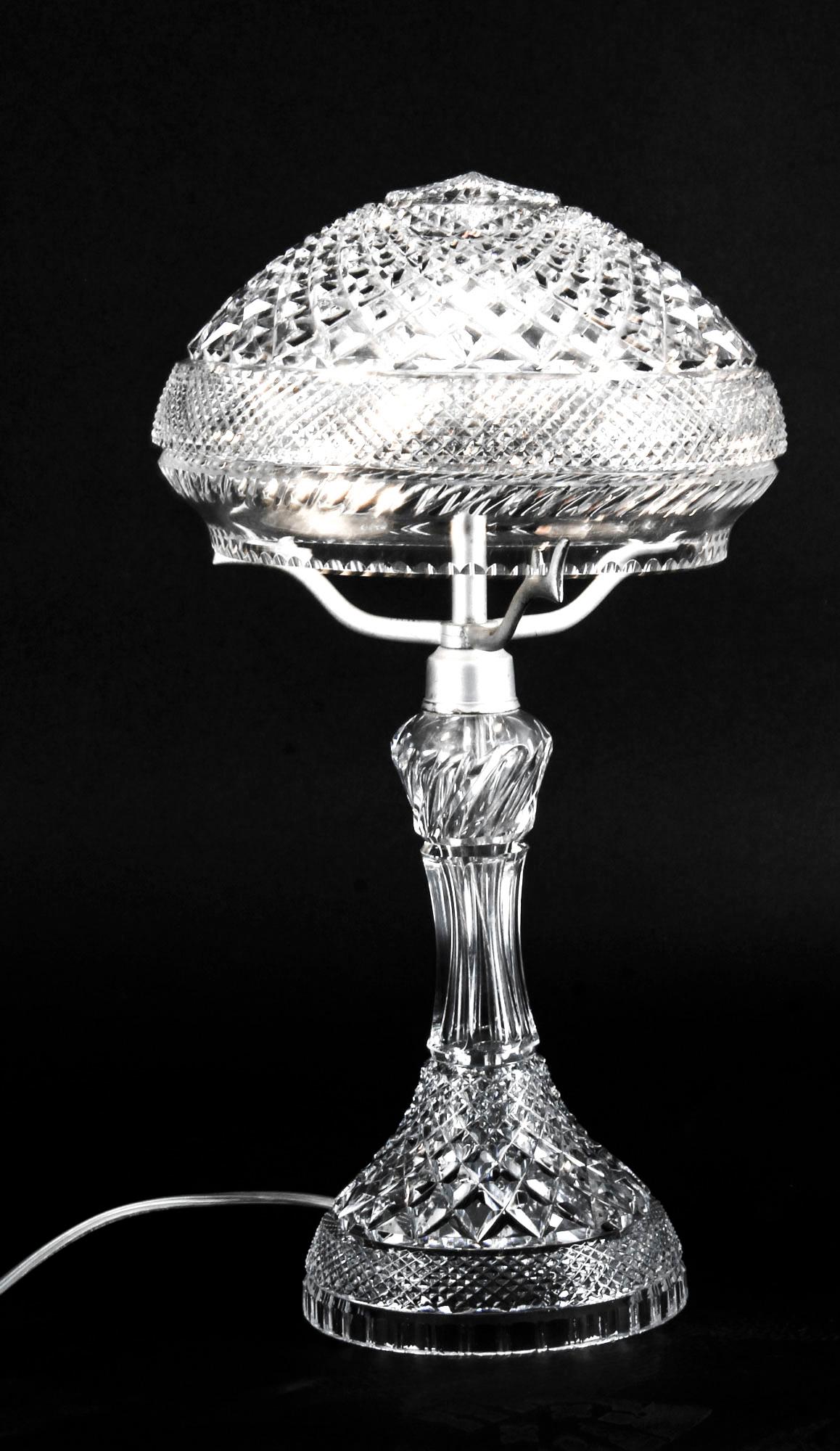 This is an elegant antique Edwardian crystal cut-glass table lamp, circa 1900 in date.

This stylish lamp has a striking elongated flared shaped pedestal stem and features a very detailed facetted cut glass mushroom shaped shade.
 
This