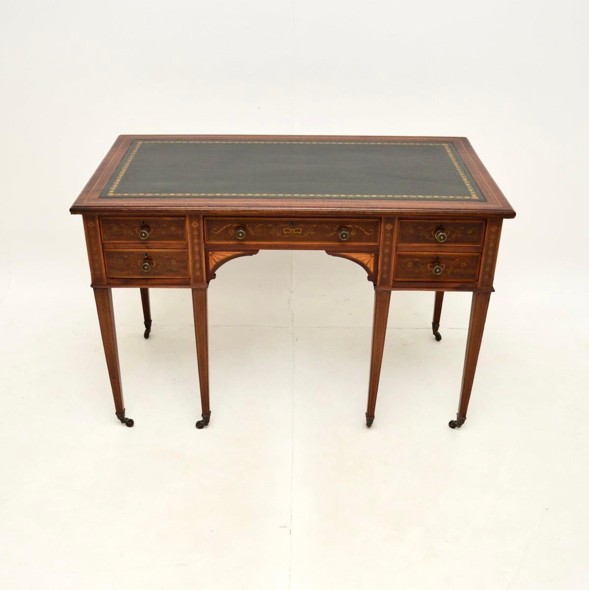 A beautiful antique Edwardian desk, made in England and dating from around the 1900-1910 period.

This is of superb quality, it is extremely well made and is a lovely size. The wood has profuse floral inlays of satinwood on the drawer fronts, the