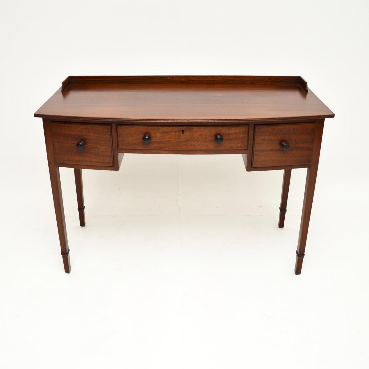 A smart and very useful antique Edwardian desk / writing table. This was made in England, it dates from around the 1900-1920 period.

The quality is superb, this has a lovely design with a slightly bow shaped front and a raised gallery at the back.