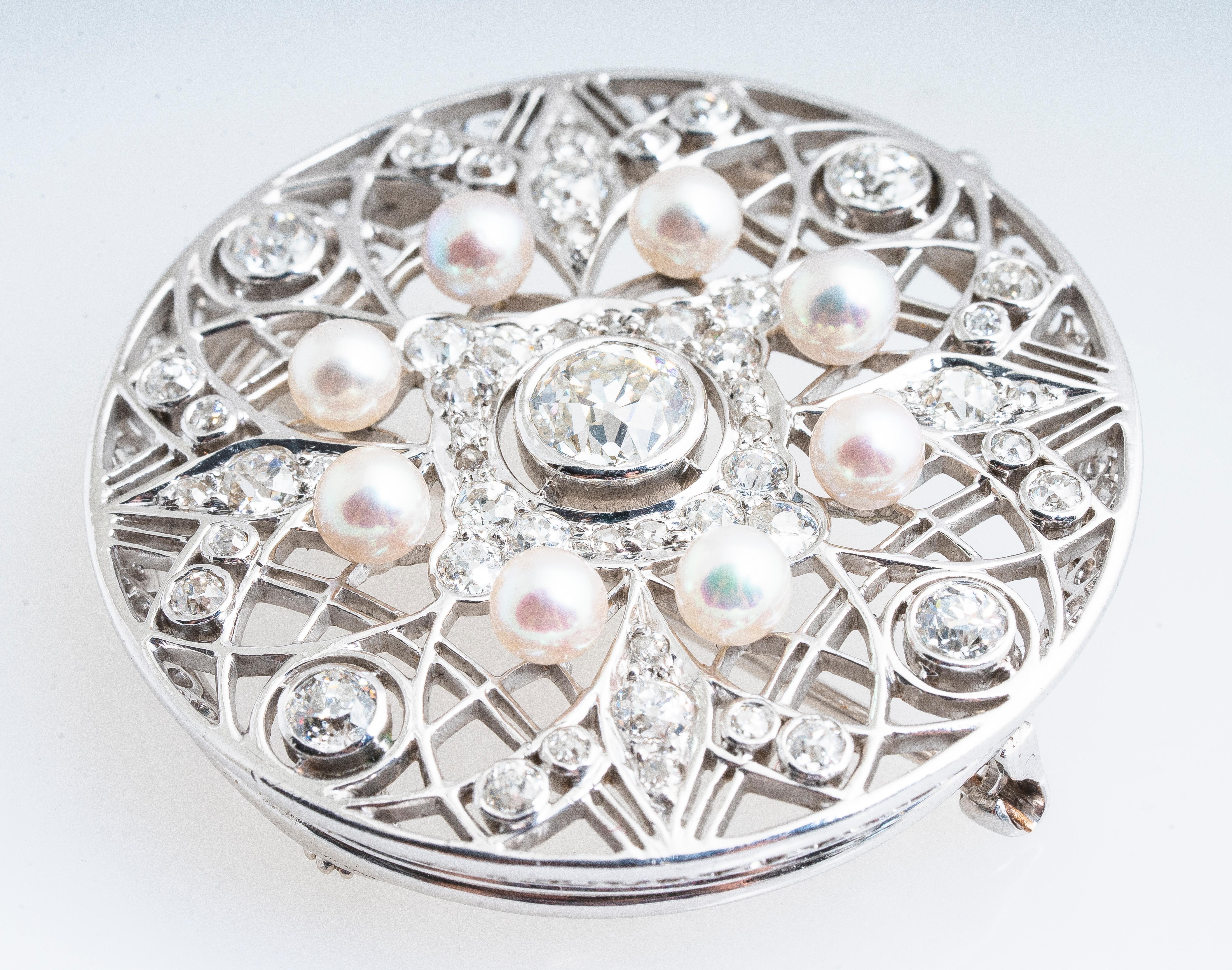 Antique Edwardian platinum diamond and pearl circle brooch and pendant.  Bezel set center diamond is 0.80ct old European cut I color and VS1 clarity surrounded by approximately 2.65 carat total weight of diamonds H-I color and VS2 clarity.  Eight