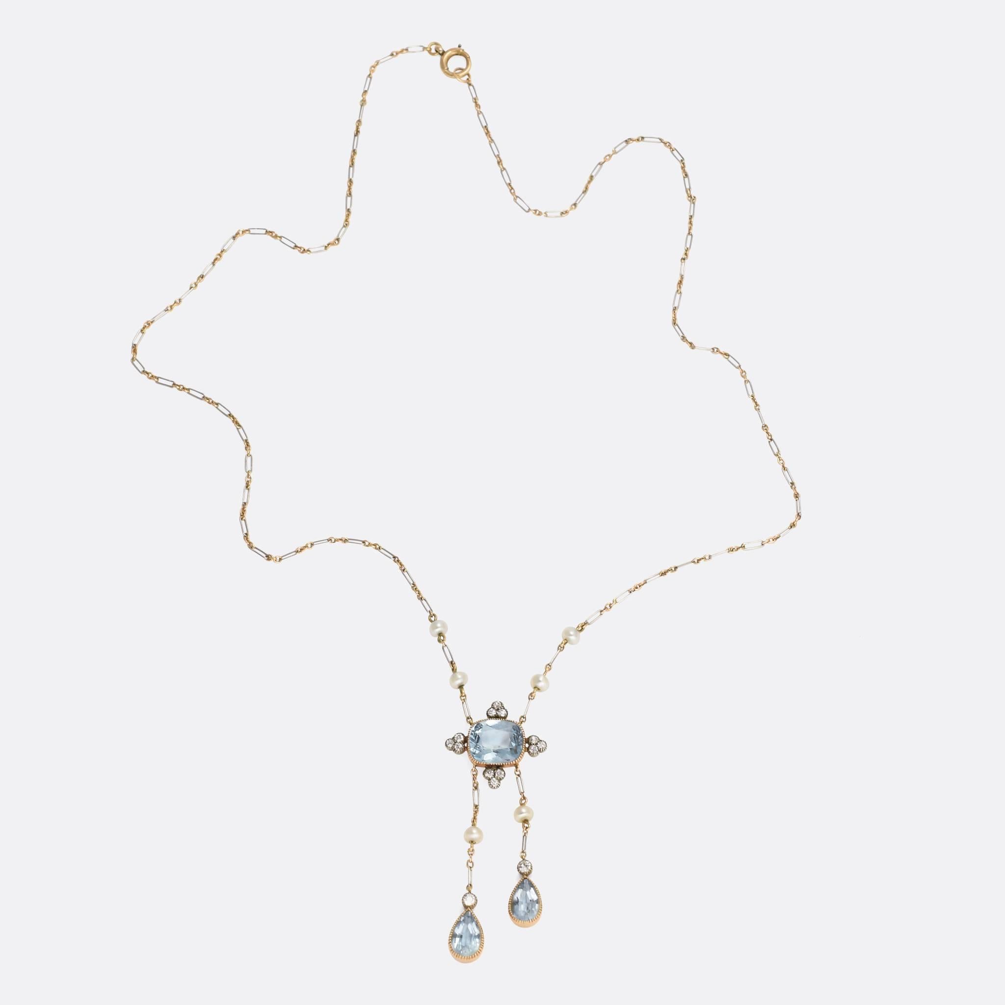 Typically Edwardian, with alternating Platinum and 18ct gold links. The principal aquamarine is surrounded by four diamond trefoils, hanging beneath, an aquamarine and diamond negligee drop and further accented by six natural pearls. Such a pretty