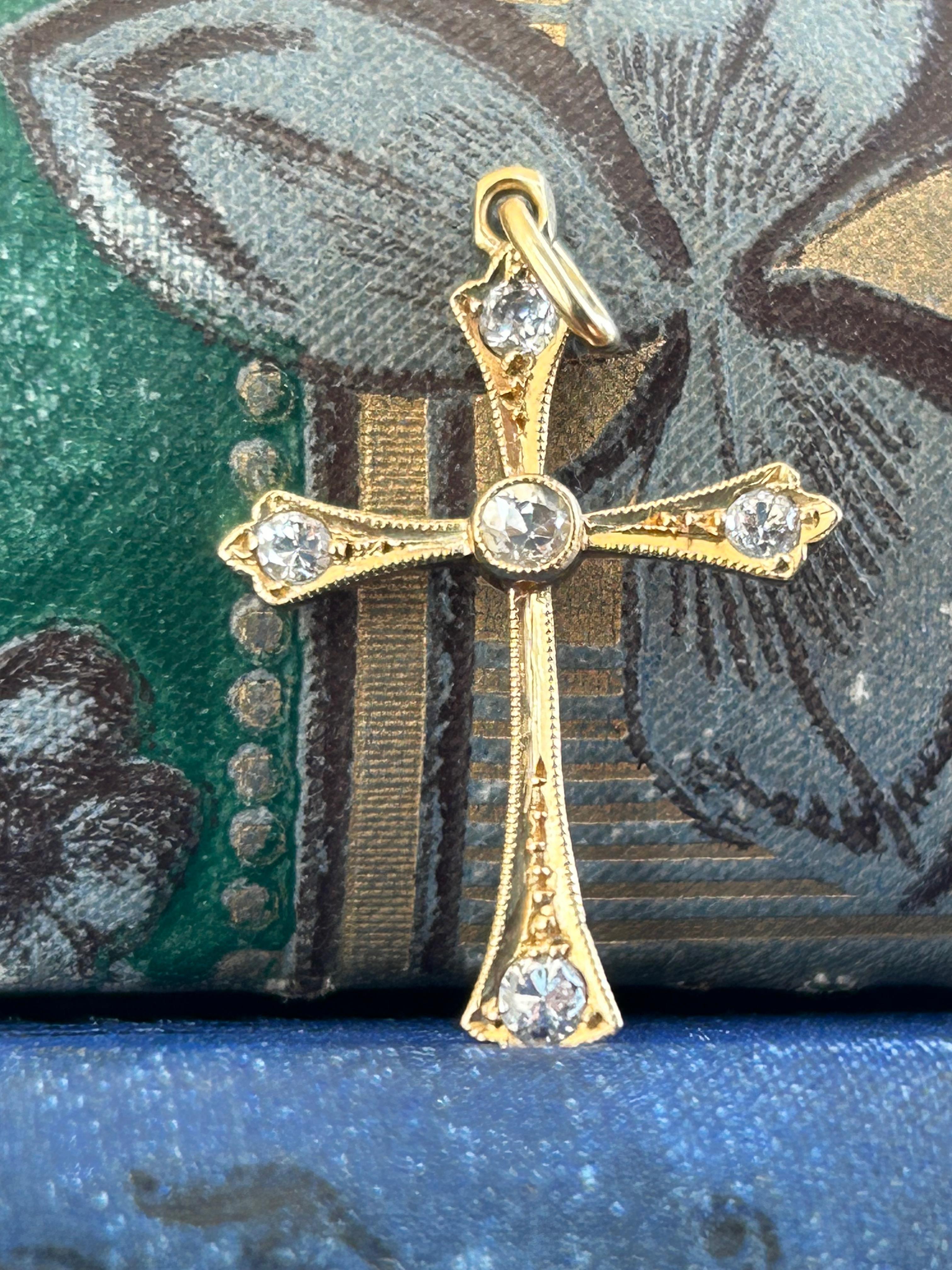 A lovely cross pendant from the Edwardian Period ( CA 1910s).  This wonderful piece is crafted in 18 karat, yellow gold and forms the shape of an ornate cross. The body of the cross is adorned with five old European cut diamonds bezel set.
The